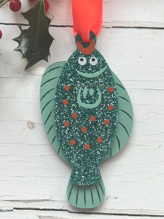glittery teal plaice fish Christmas decoration with red ribbon, coastal ocean-themed festive ornament for holiday décor