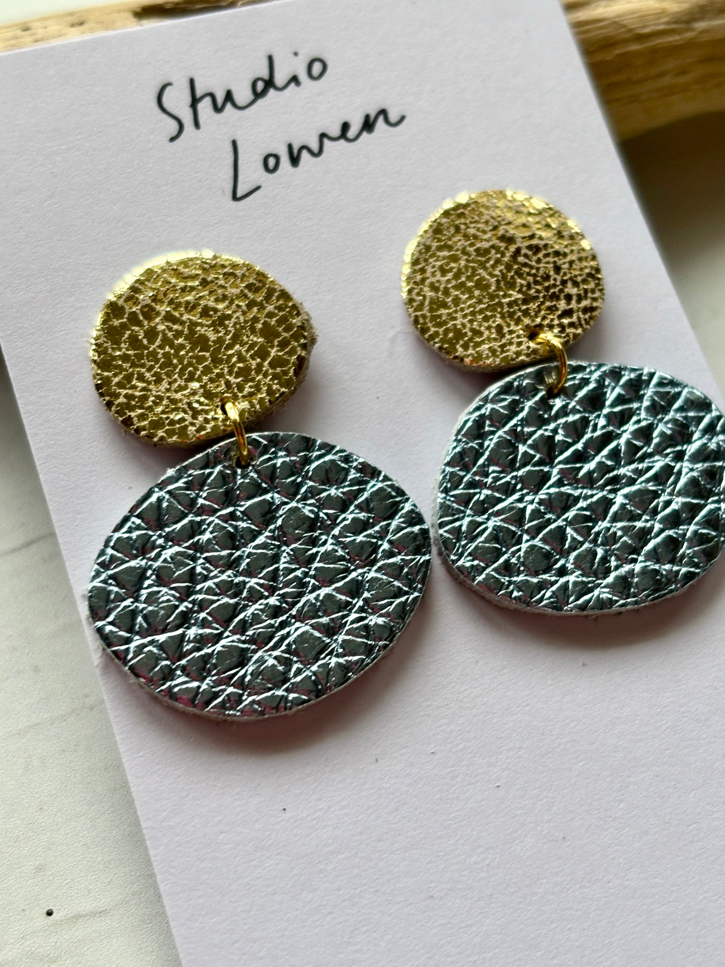 closeup shot of metallic blue and gold dangle earrings handmade polymer clay textured jewelry two-tone statement piece