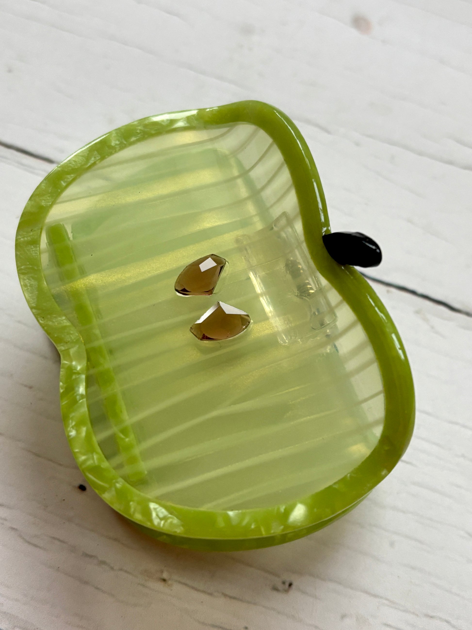 glossy green apple hair claw with striped body and gem-like seeds—playful, secure grip for everyday styling