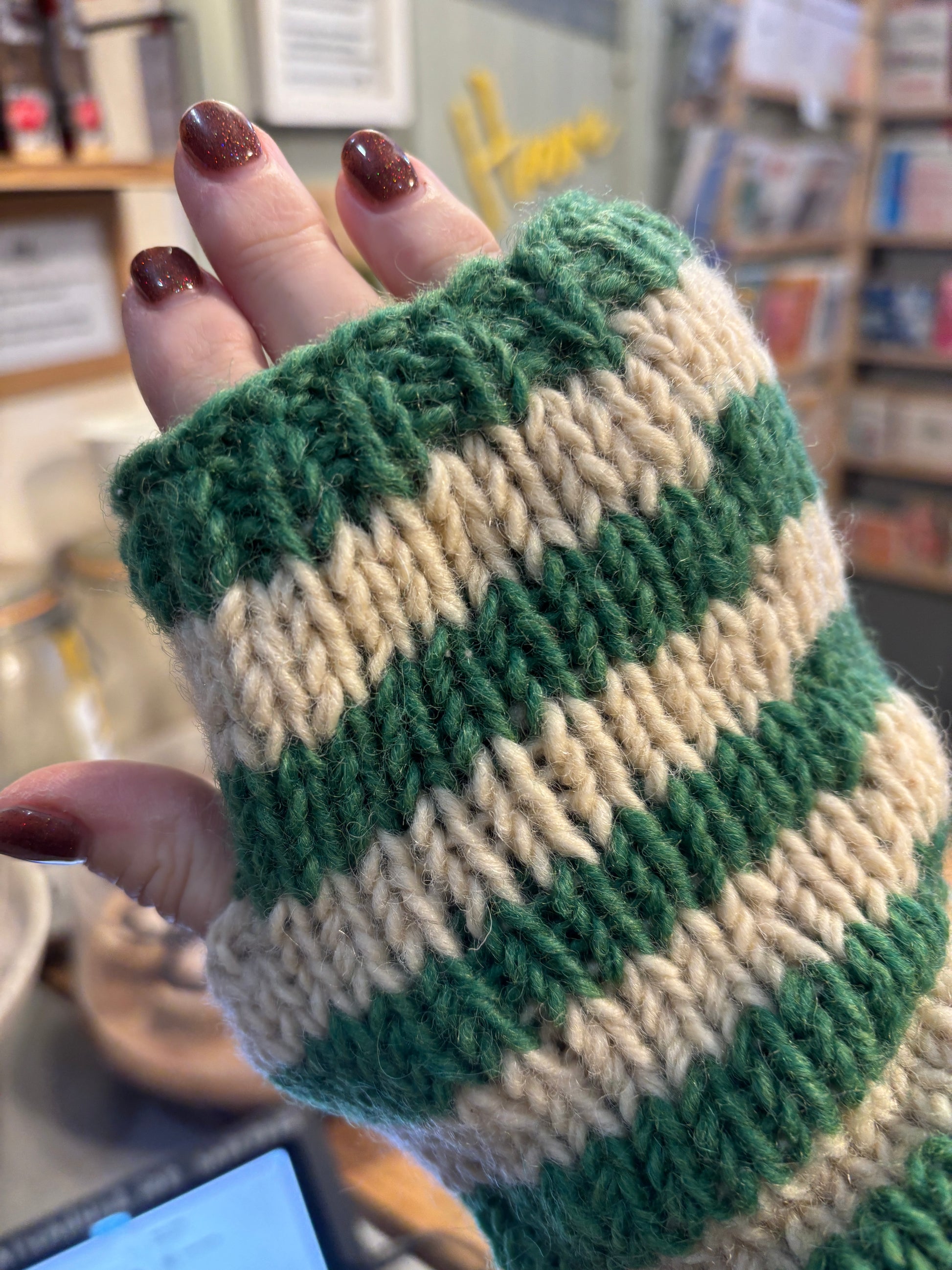 hand modeling green cream striped fingerless gloves - chunky knit wool hand warmers with thumb holes closeup