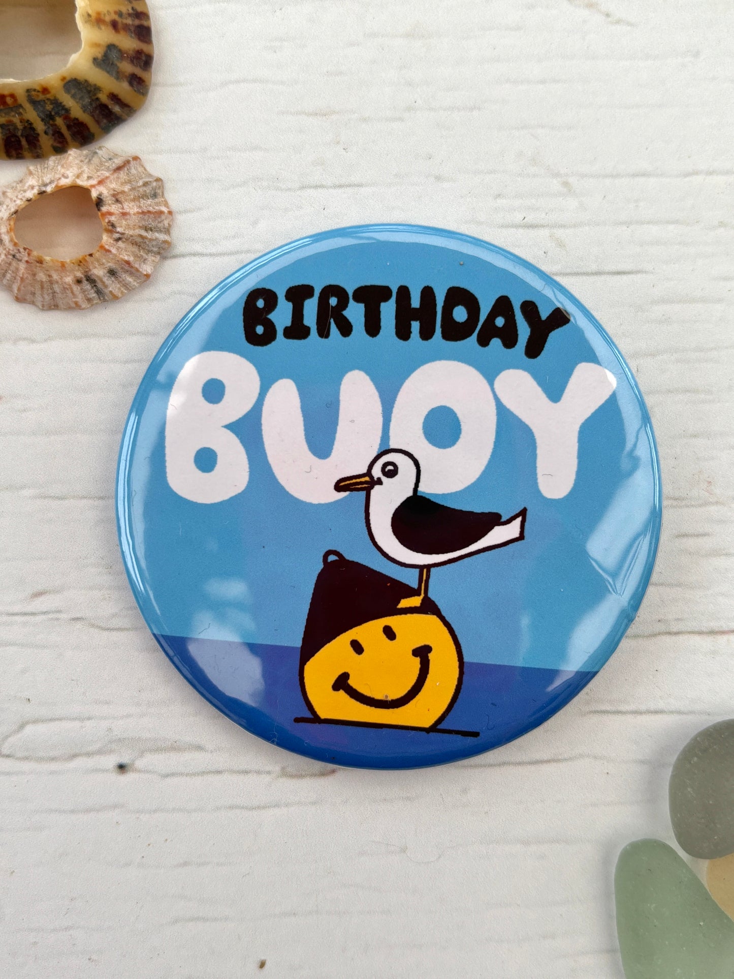 blue seagull pin badge with the text 'Birthday Buoy' a funny nautical accessory, perfect as a coastal birthday gift or party favour