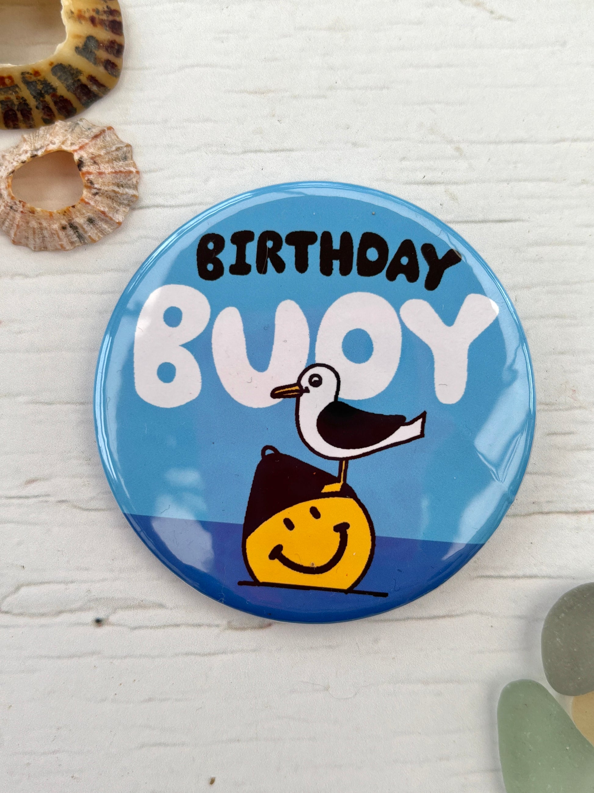 blue seagull pin badge with the text 'Birthday Buoy' a funny nautical accessory, perfect as a coastal birthday gift or party favour