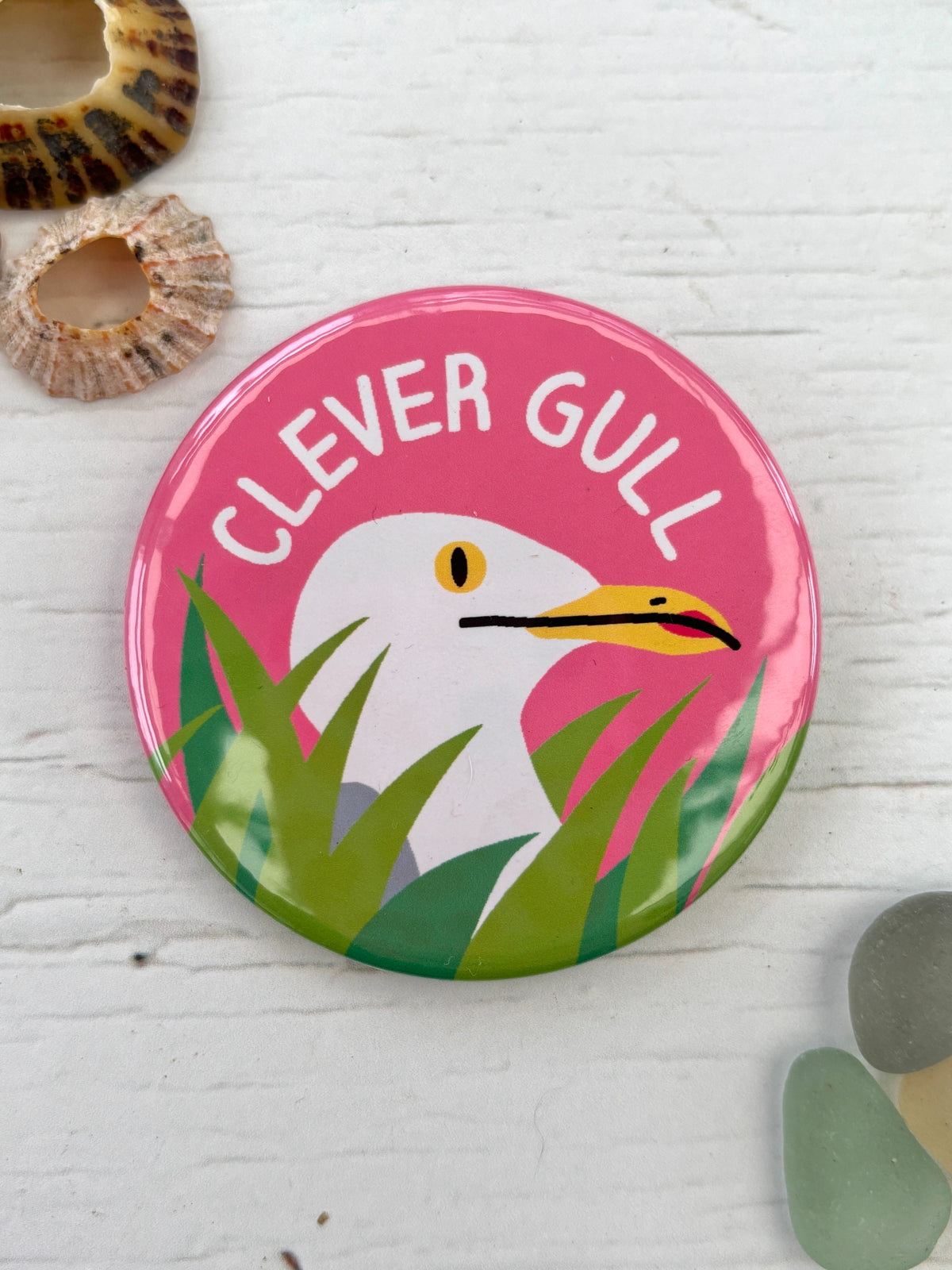 pink seagull badge with the text 'Clever Gull' hiding in tall grass funny novelty pin and coastal gift for bird lovers