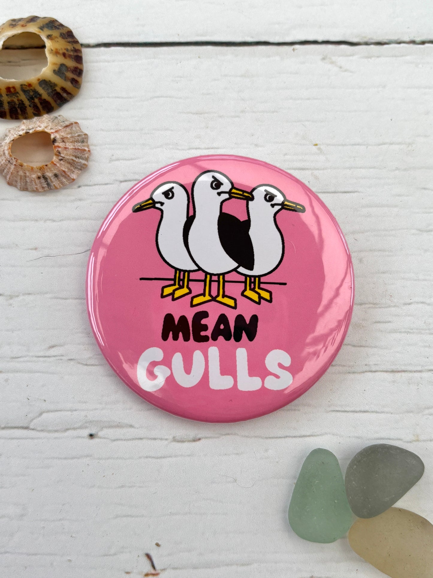 pink seagull badge with the text 'Mean Gulls' showing three angry birds a funny novelty pin and nautical accessory great coastal souvenir