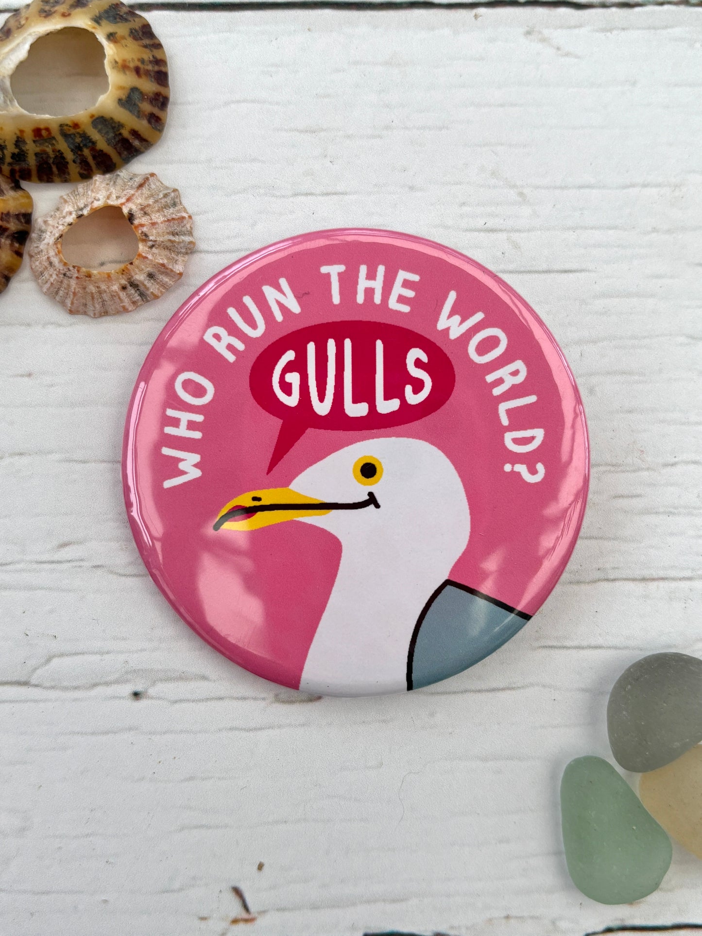 pink seagull badge with the text 'Who Run The World? Gulls' funny feminist pin and nautical accessory freat coastal novelty gift