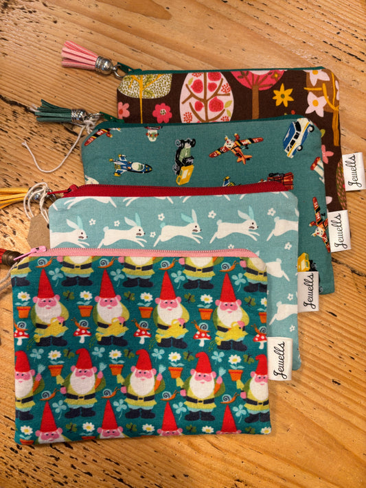 stack of four handmade fabric zipped purses with quirky prints (gnomes, rabbits, vehicles, trees) small coin pouch and unique gift accessory