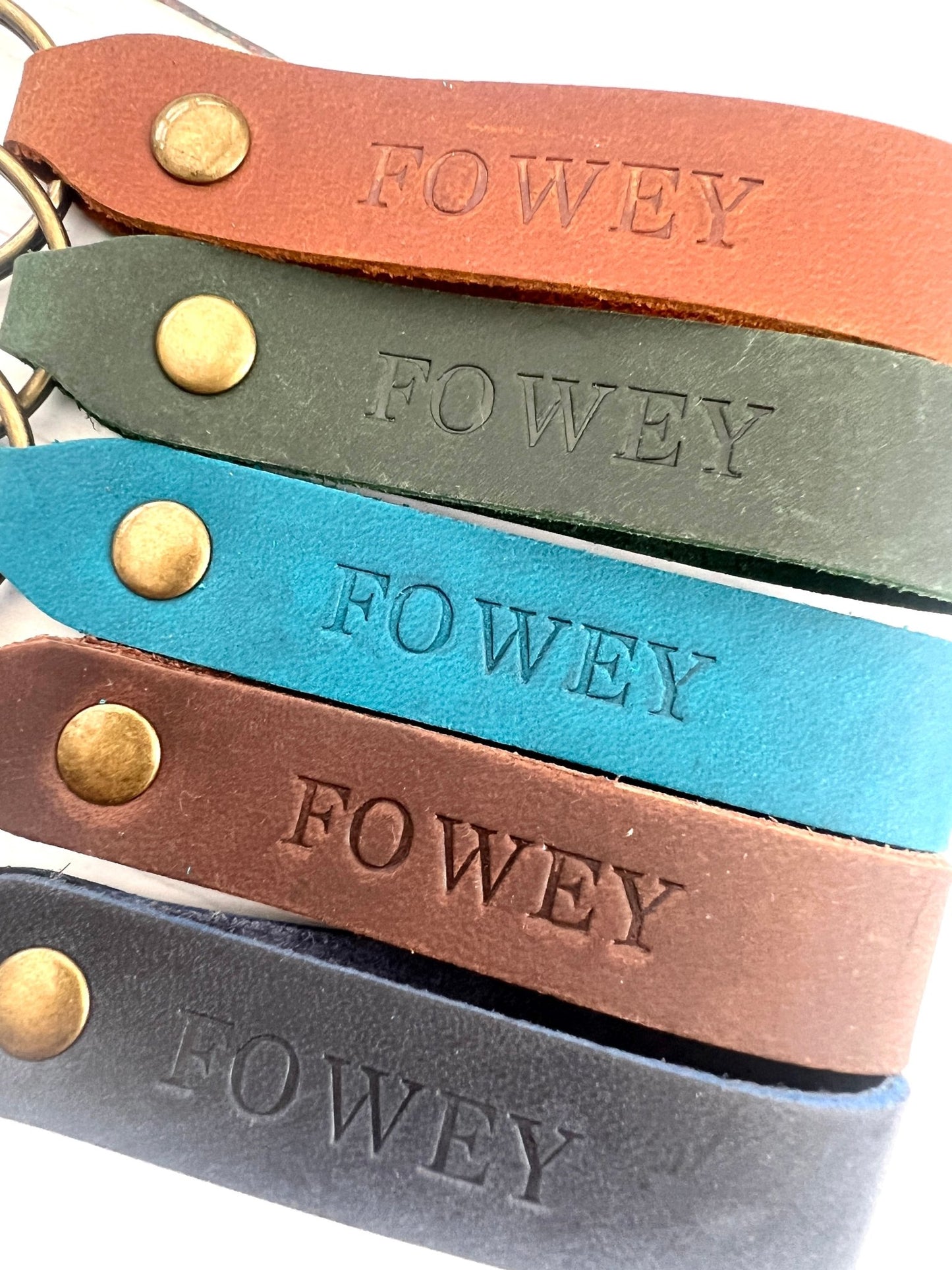 assorted handmade stamped leather keyrings in Fowey design, rustic coastal souvenir, colourful loop keychain accessories