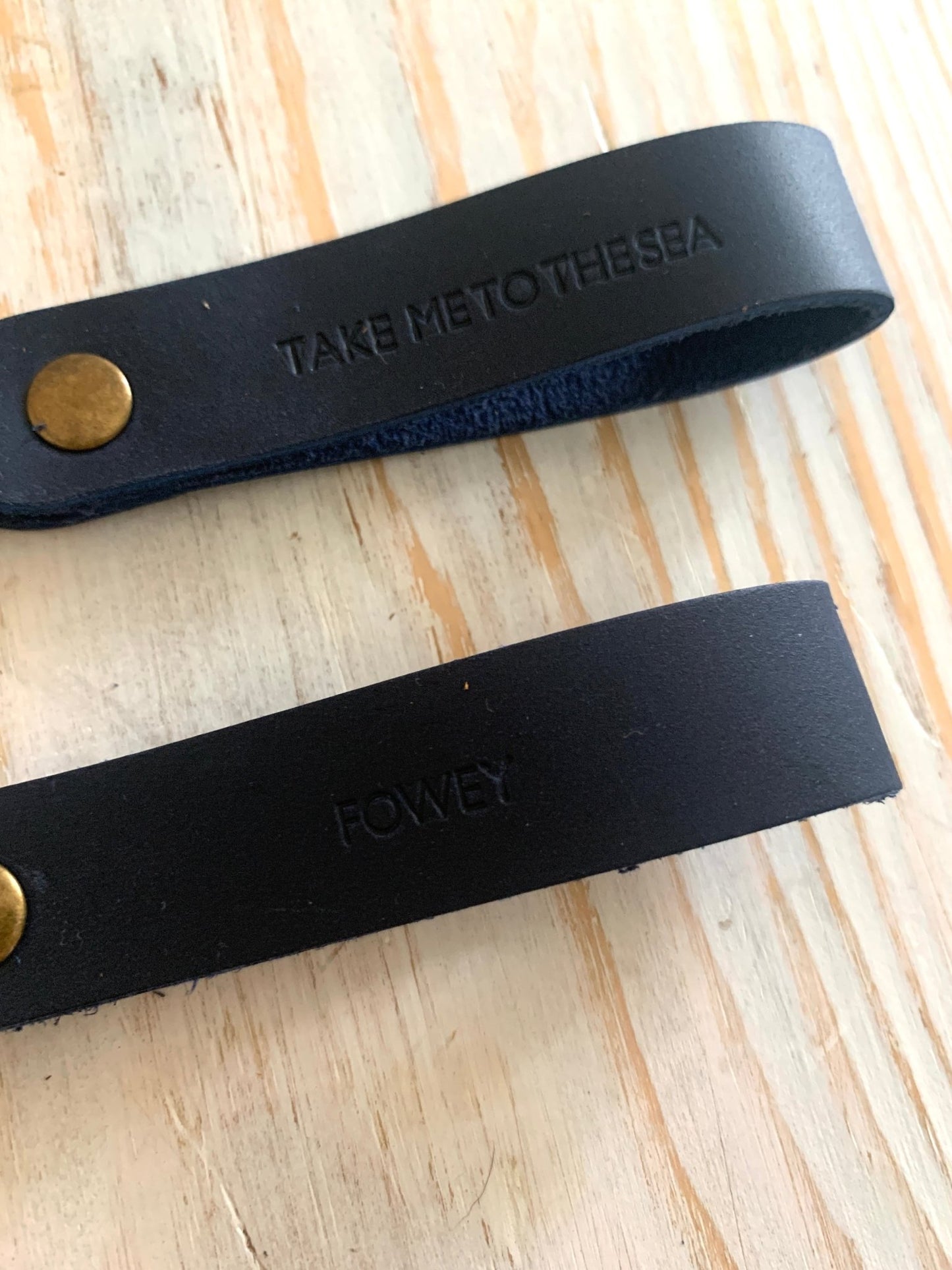 handmade dark navy leather keyring—brass ring with embossed “Fowey” and “Take Me to the Sea” coastal design