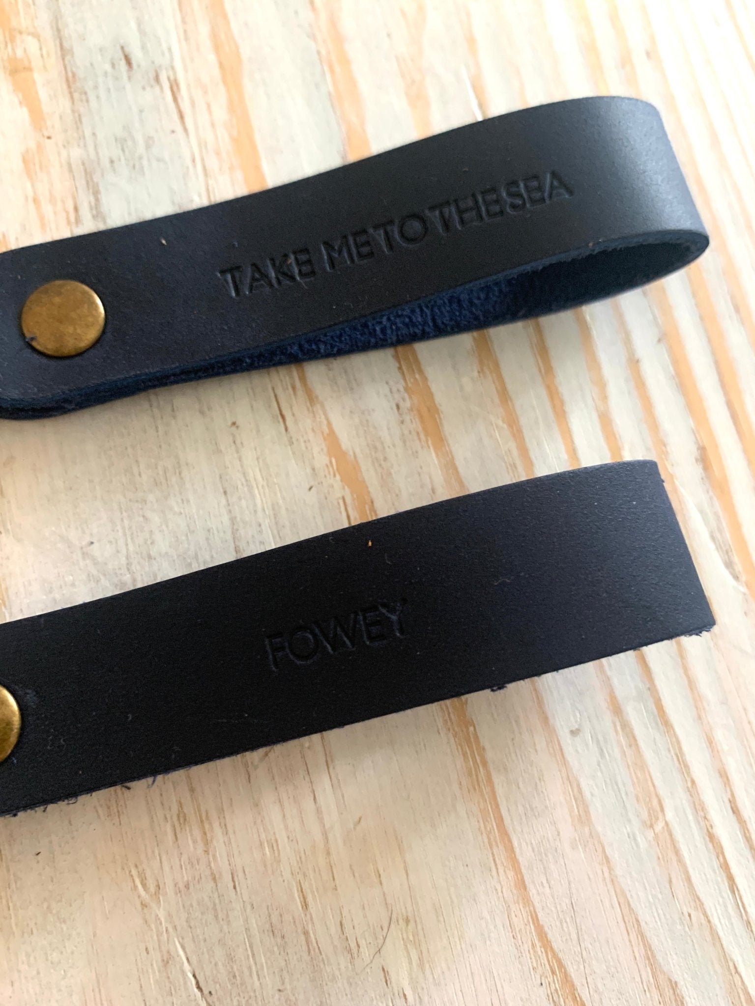 handmade dark navy leather keyring—brass ring with embossed “Fowey” and “Take Me to the Sea” coastal design
