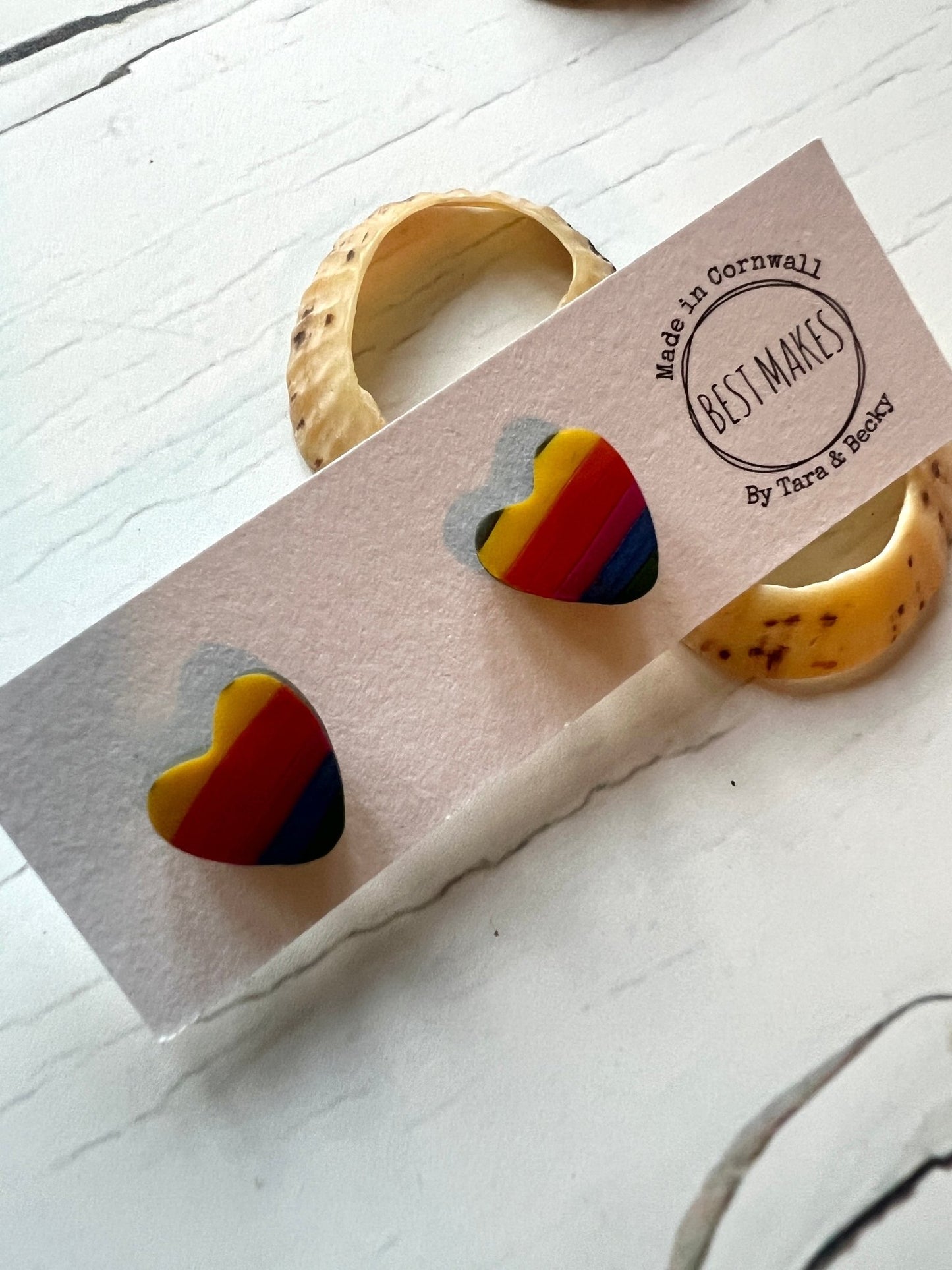 handmade resin stud earrings shaped like hearts with a bright rainbow stripe design funky statement jewellery, perfect as a colorful gift