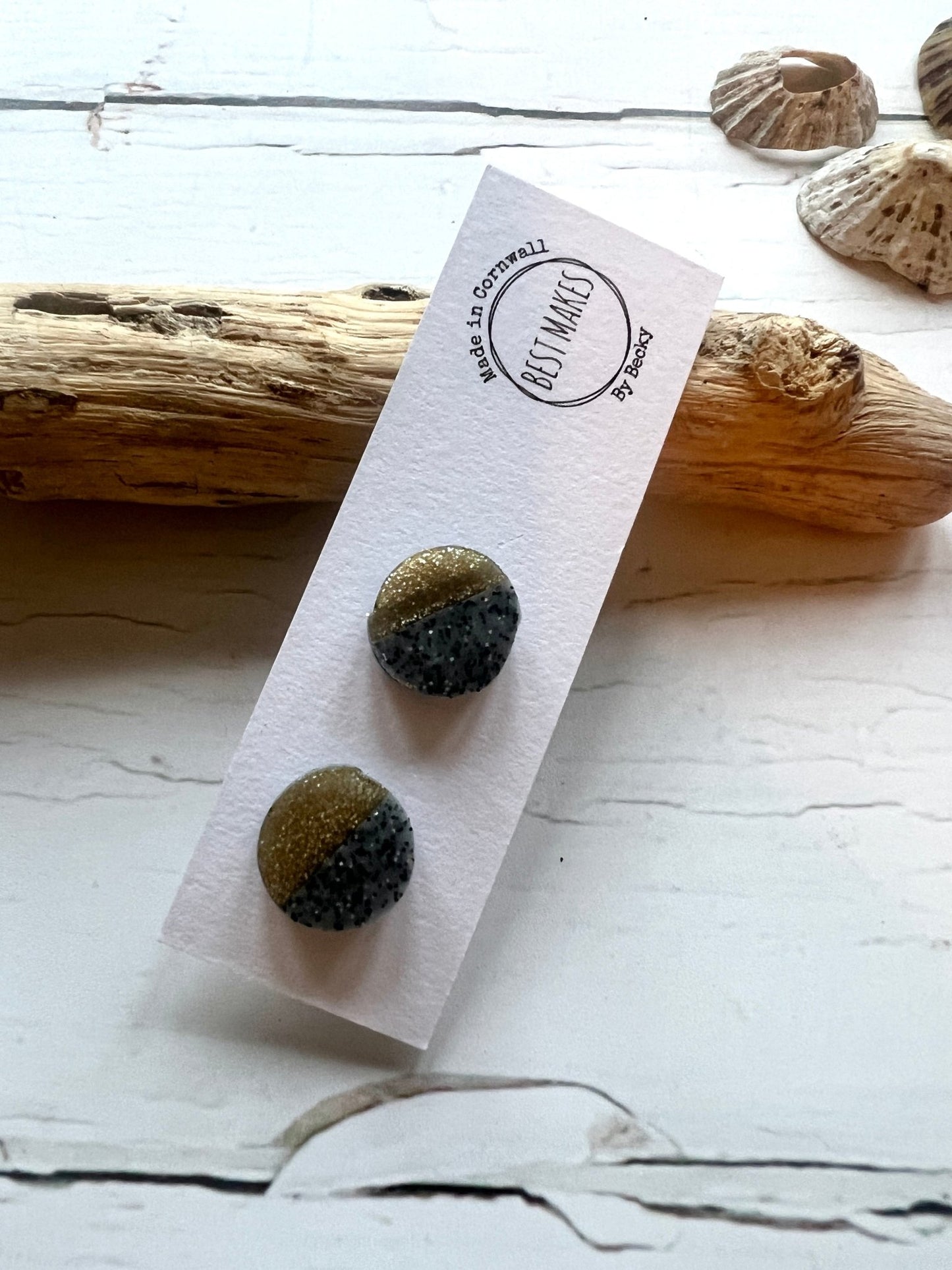 handmade resin stud earrings with a two-tone glitter design in charcoal grey and metallic gold modern statement jewellery made in Cornwall