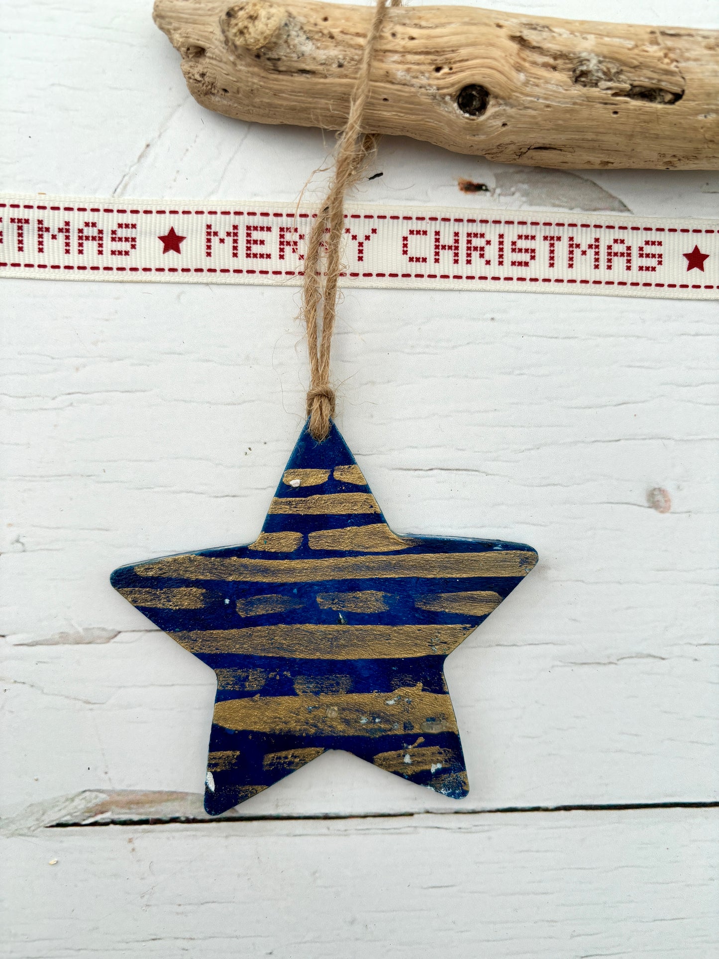 navy blue hand-painted wooden star decoration with distressed metallic gold stripes hanging from twine rustic coastal Christmas ornament or nautical decor