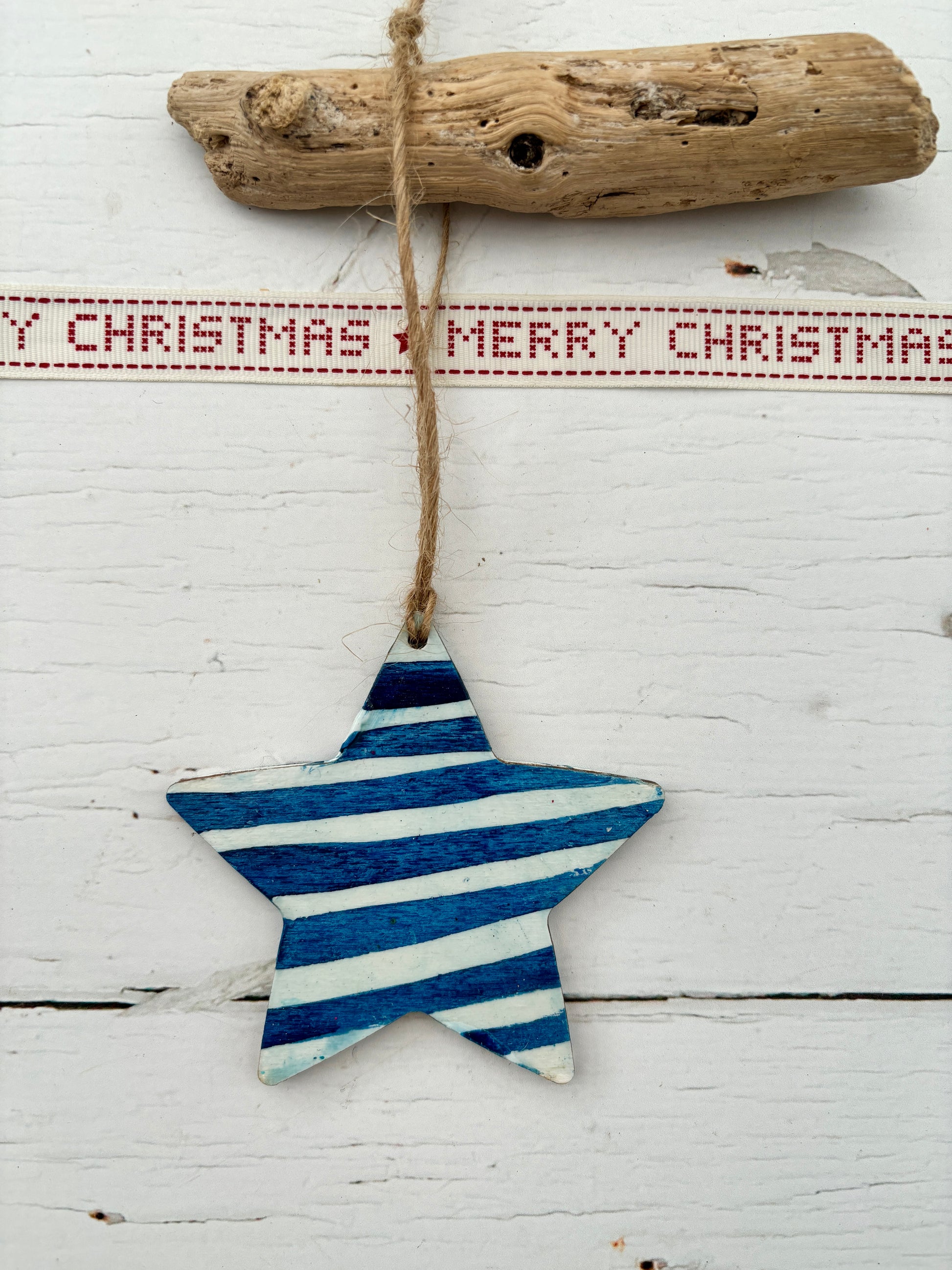 blue hand-painted wooden star decoration with white nautical stripes hanging from twine rustic coastal Christmas ornament or beach home decor