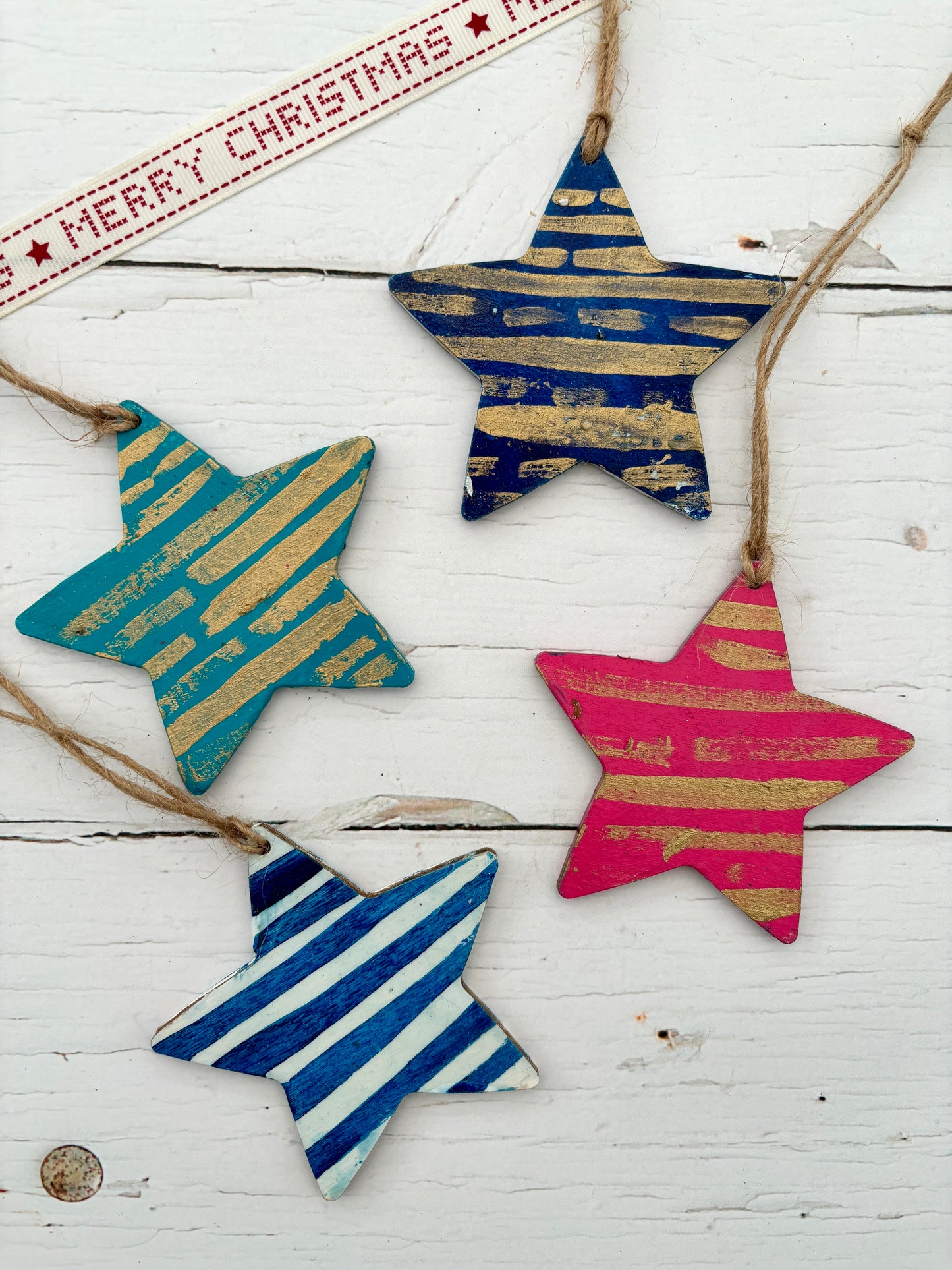 four hand-painted wooden star hanging decorations in blue, teal, and pink with gold or white distressed stripes nautical Christmas decor or coastal gift