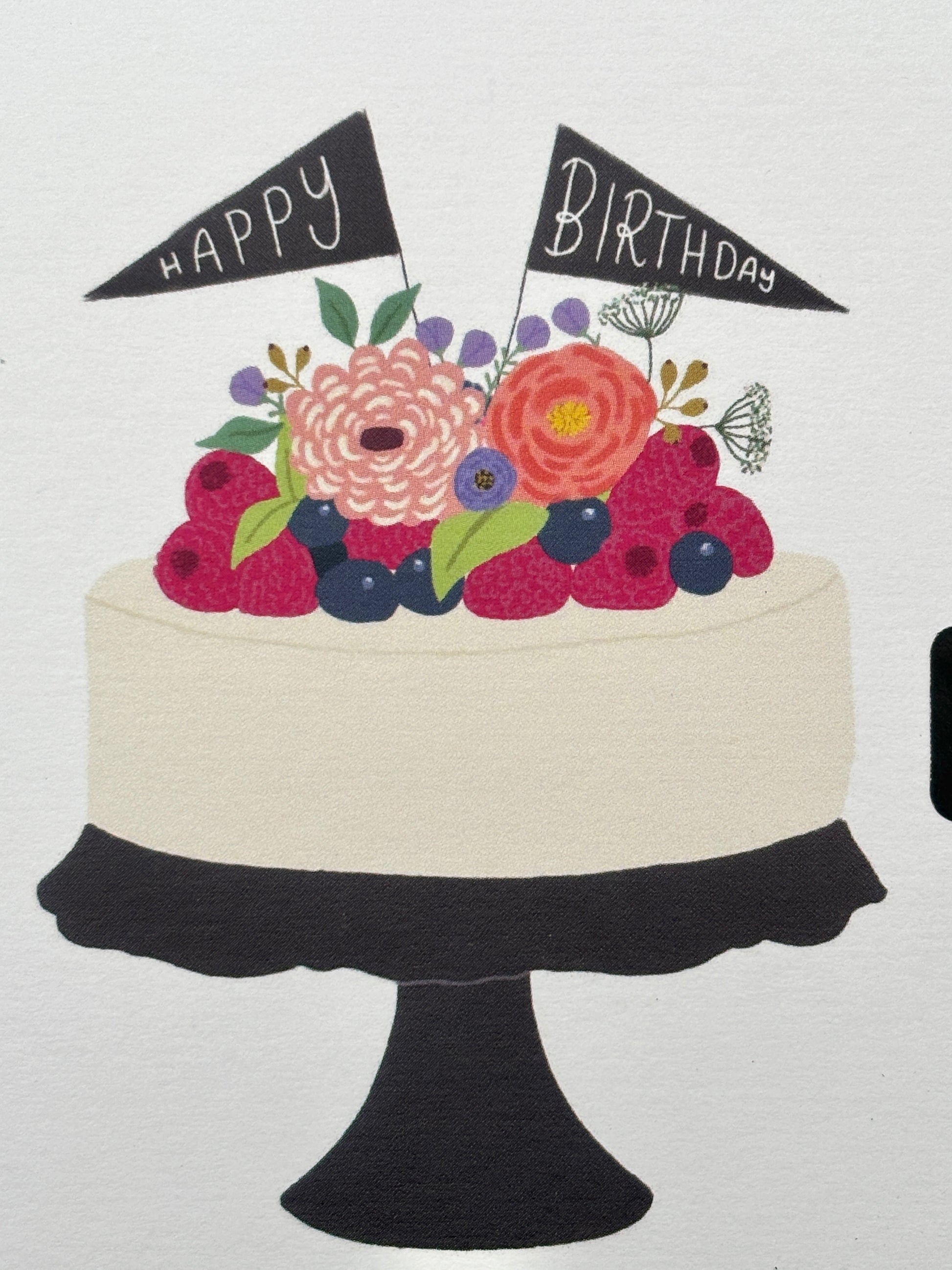 closeup shot of a Happy Birthday card showing a cake illustration topped with flowers, berries, and small "Happy Birthday" flags hand-drawn greeting card