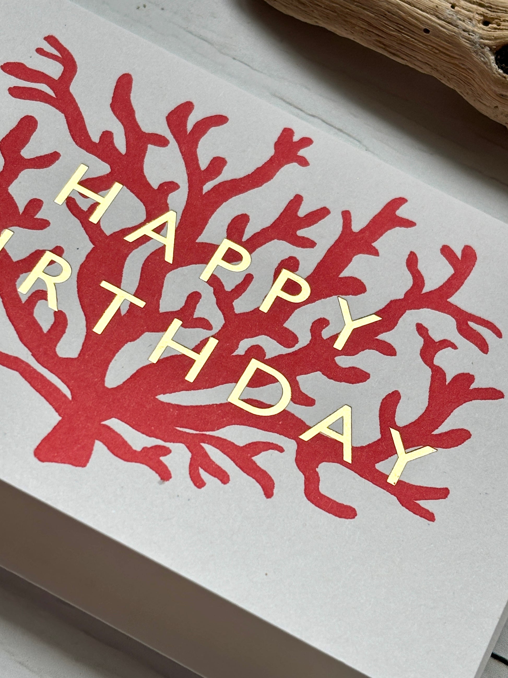 closeup shot of coral birthday card—red reef design with gold foil text, perfect for ocean lovers and coastal-themed gifting