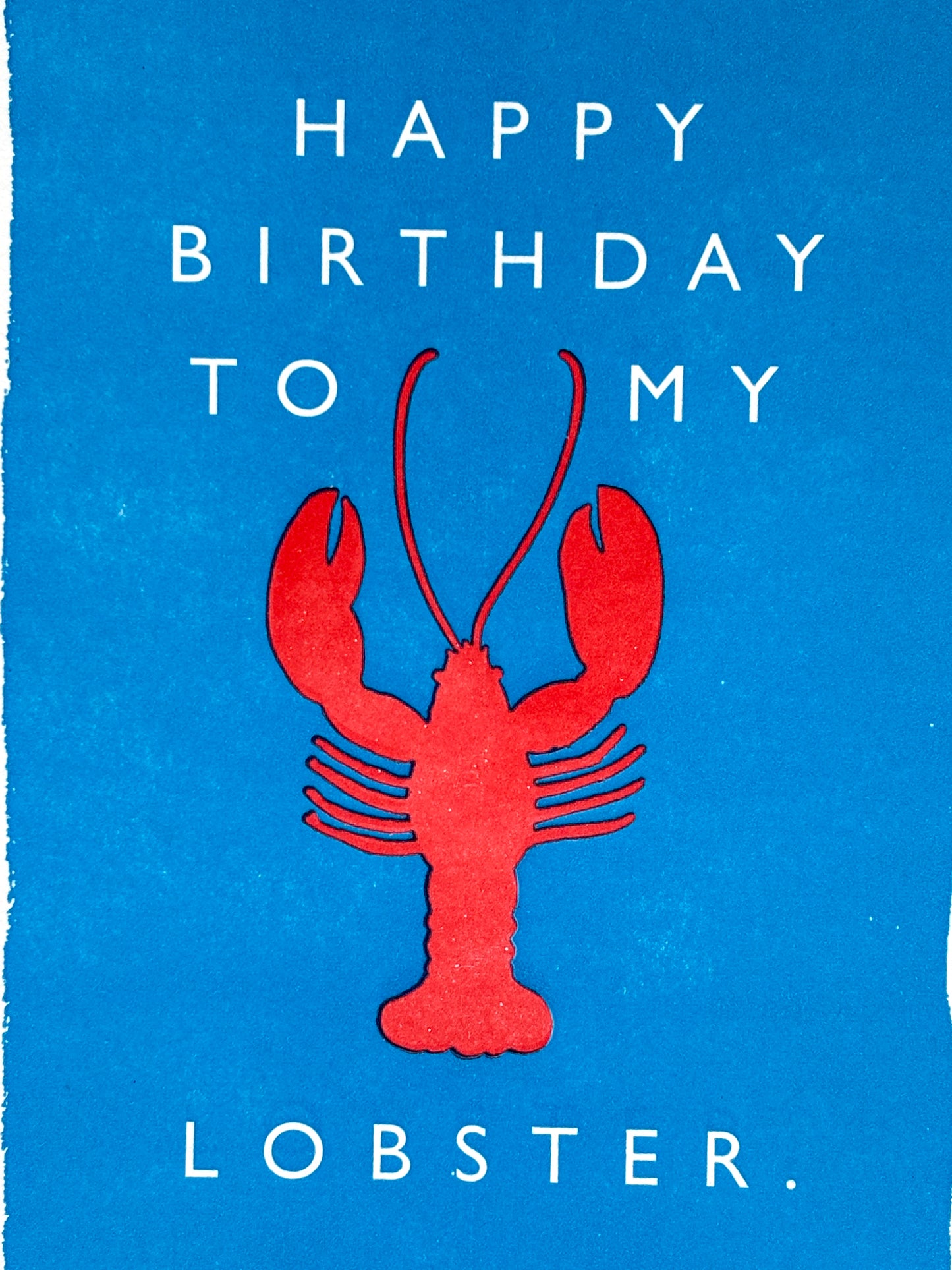 closeup shot of lobster birthday card with red lobster on blue, playful romantic design for coastal gifting and ocean-loving couples