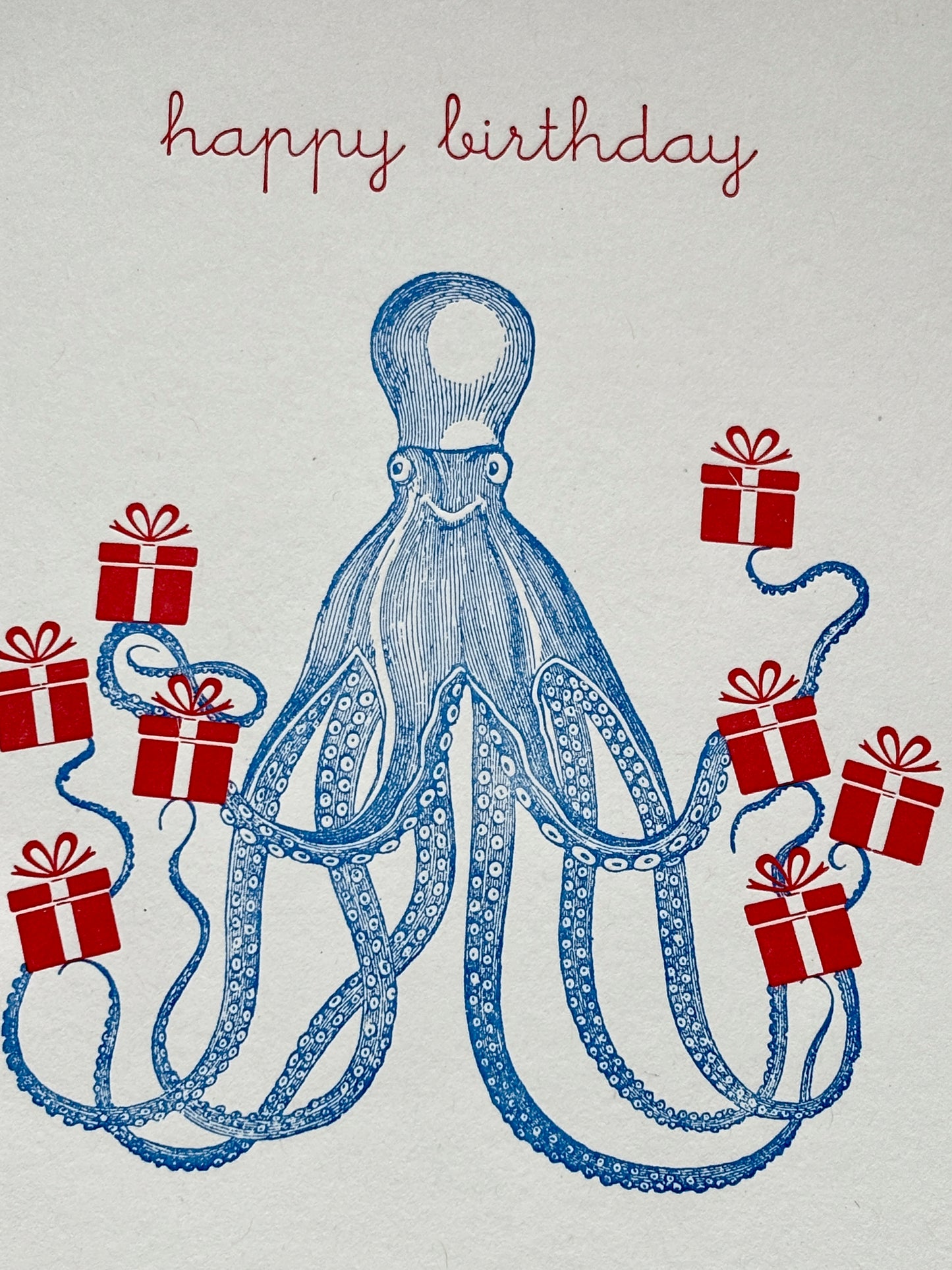 closeup shot of octopus birthday card with red gifts on blue, whimsical ocean-themed design for playful coastal celebrations