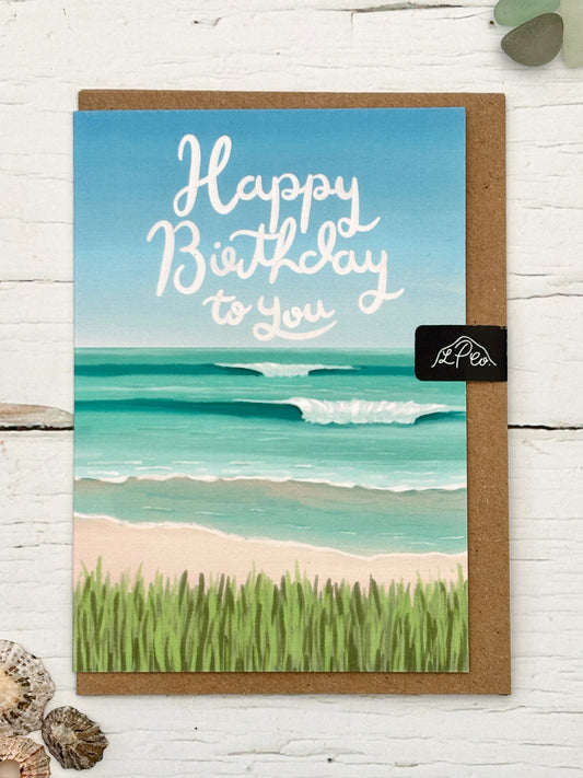 Happy Birthday card featuring a coastal painting of a beach and turquoise ocean waves hand-painted artwork for sea swimmers and beach lovers