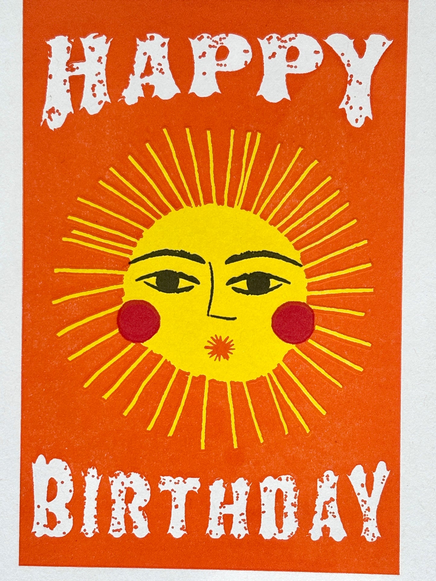 closeup shot of sunshine birthday card with bold sun face and white text on orange, perfect for cheerful coastal-themed gifting