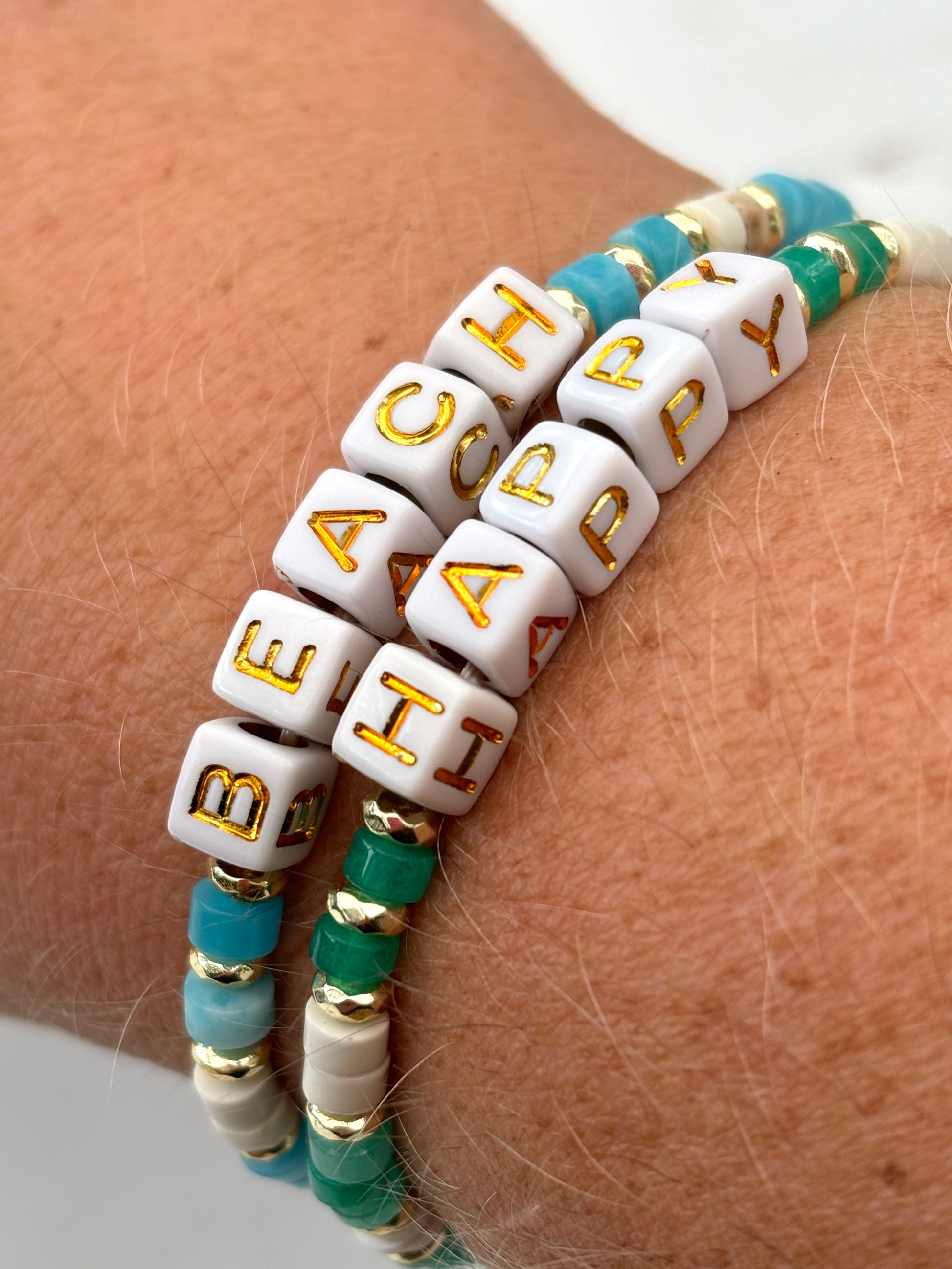 stacked beach bracelets—turquoise, gold, and white beads with “BEACH,” “HAPPY,” cubes, handmade coastal gift