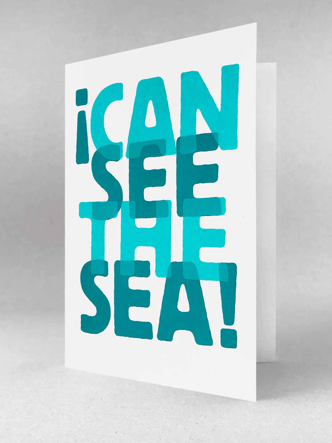 bold seaside greeting card—“I Can See the Sea” design in layered blue text, fun coastal stationery for ocean lovers