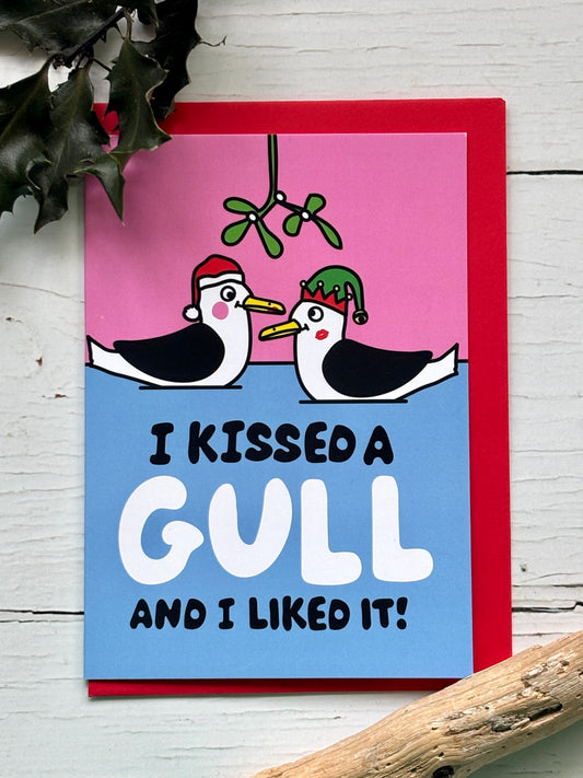 funny Christmas card featuring kissing gulls under mistletoe, playful seaside illustration, humorous festive greeting card
