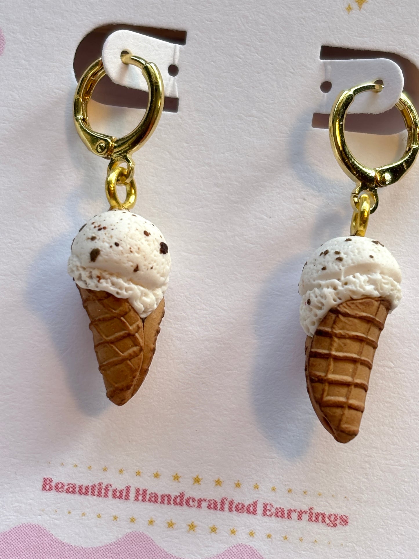 closeup shot of vanilla ice cream cone earrings handcrafted polymer clay food novelty jewelry with gold hoops
