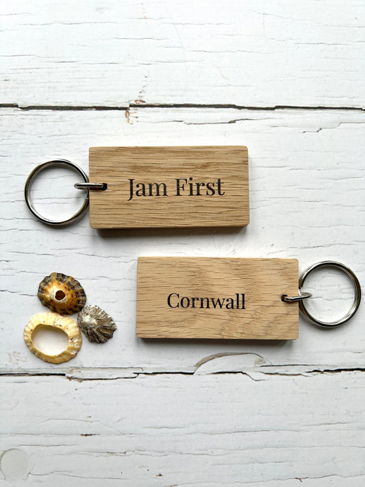 wooden key rings engraved with “Jam First” and “Cornwall”—handmade coastal accessories, perfect gift for cream tea lovers