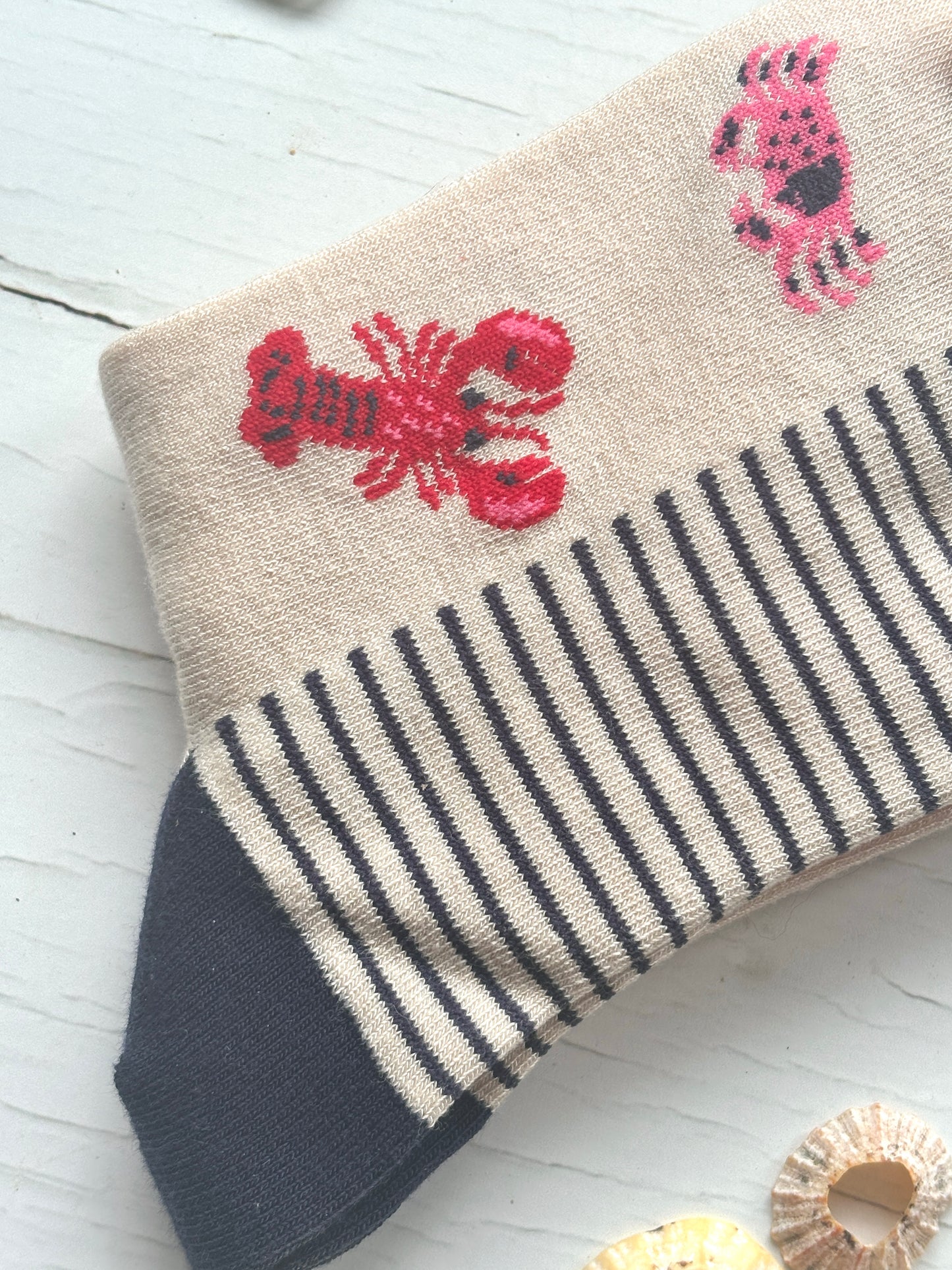 closeup shot of knit sock red lobster, pink crab, and a navy striped cuff unique bamboo coastal apparel and sea life gift