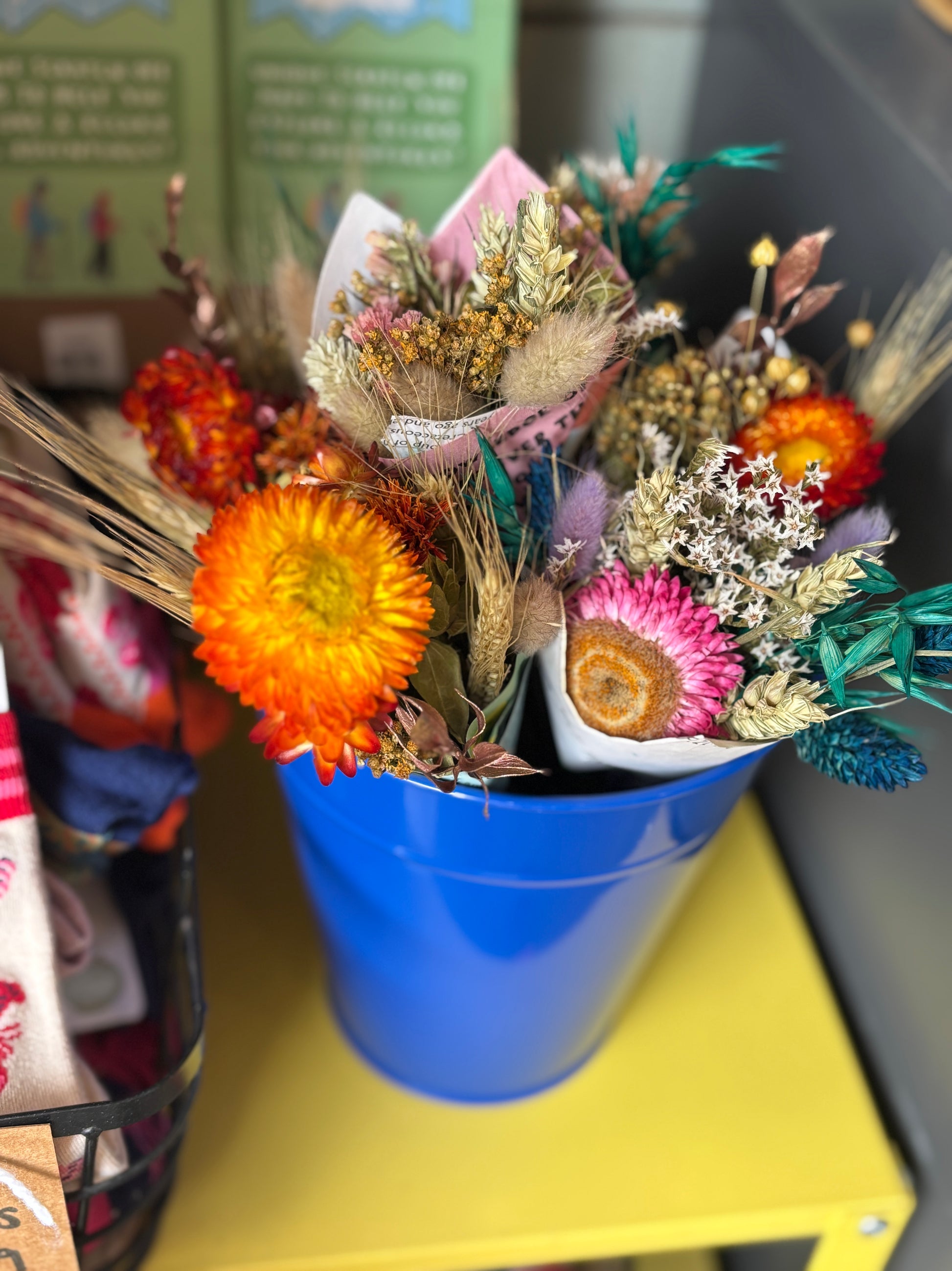 closeup shot of mini dried flower bunch in blue bucket with strawflowers, bunny tails, wheat—vibrant rustic decor or gift idea