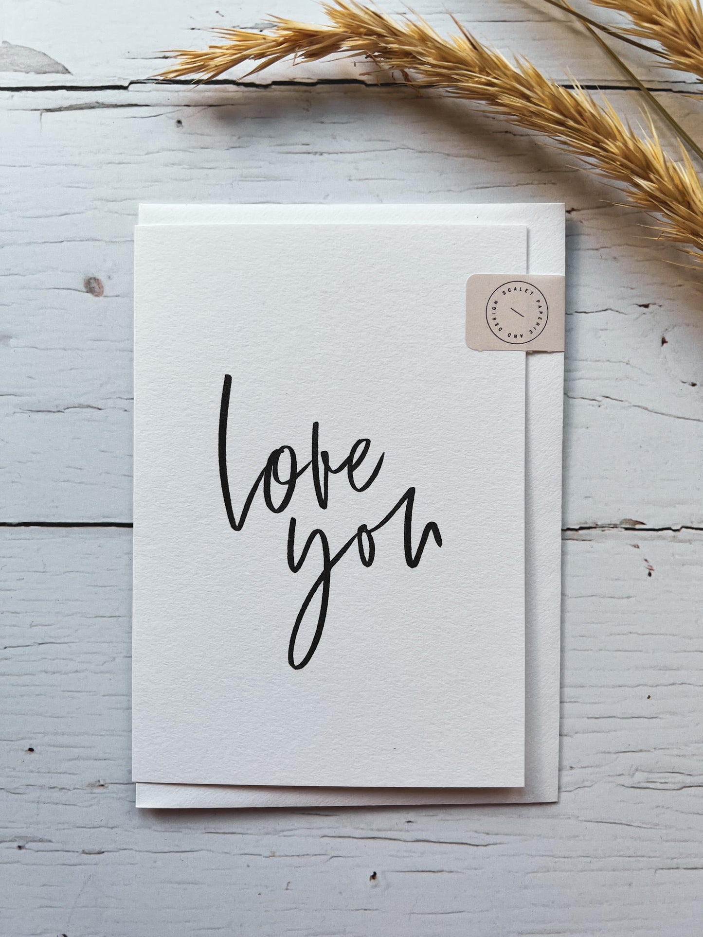 minimalist Valentine’s Day card with elegant “love you” script, neutral palette, and artisanal USA-made tag—perfect for heartfelt notes