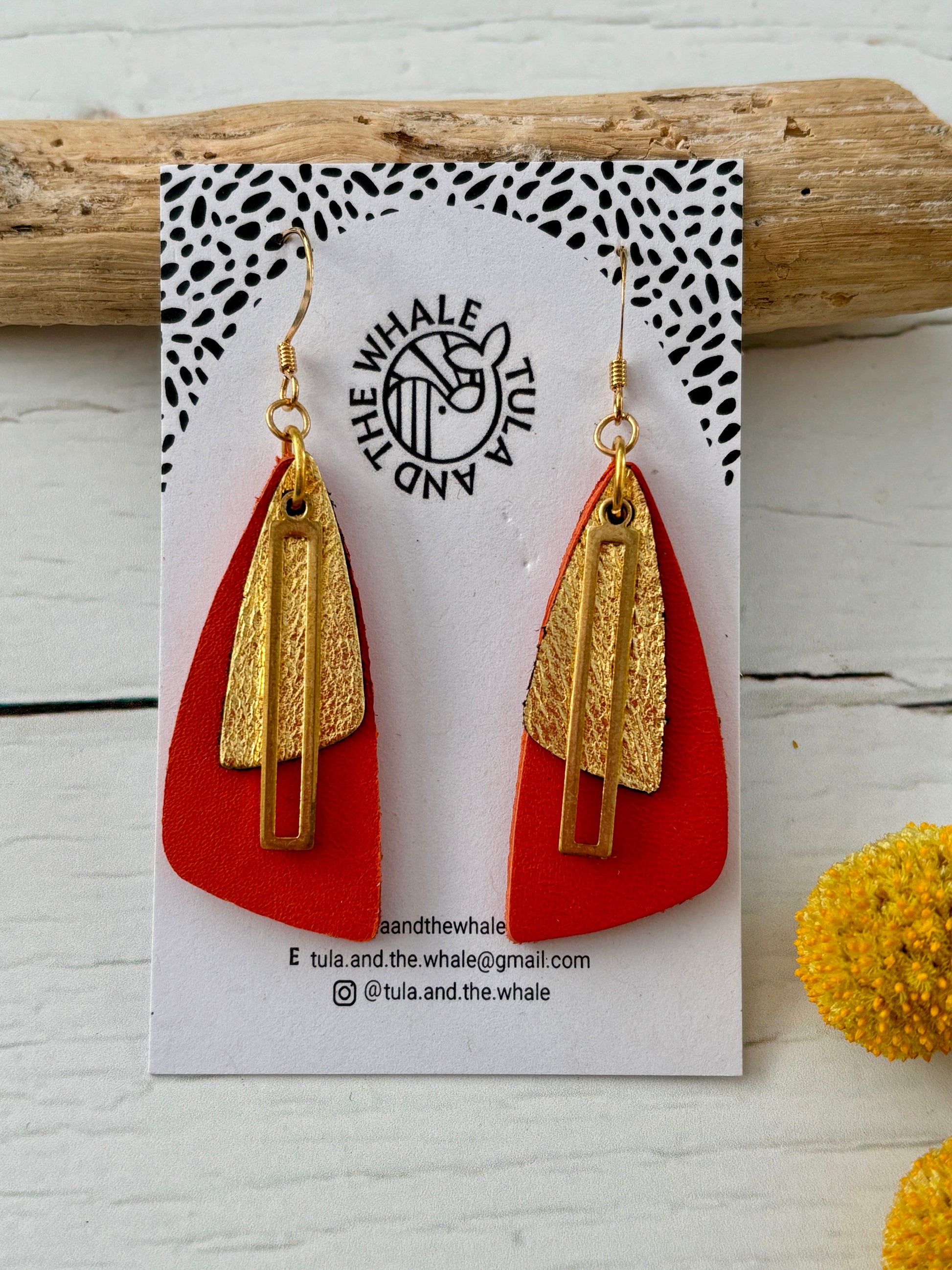 handmade orange and gold leather earrings with moth-wing silhouette—bold, lightweight, and nature-inspired statement jewelry