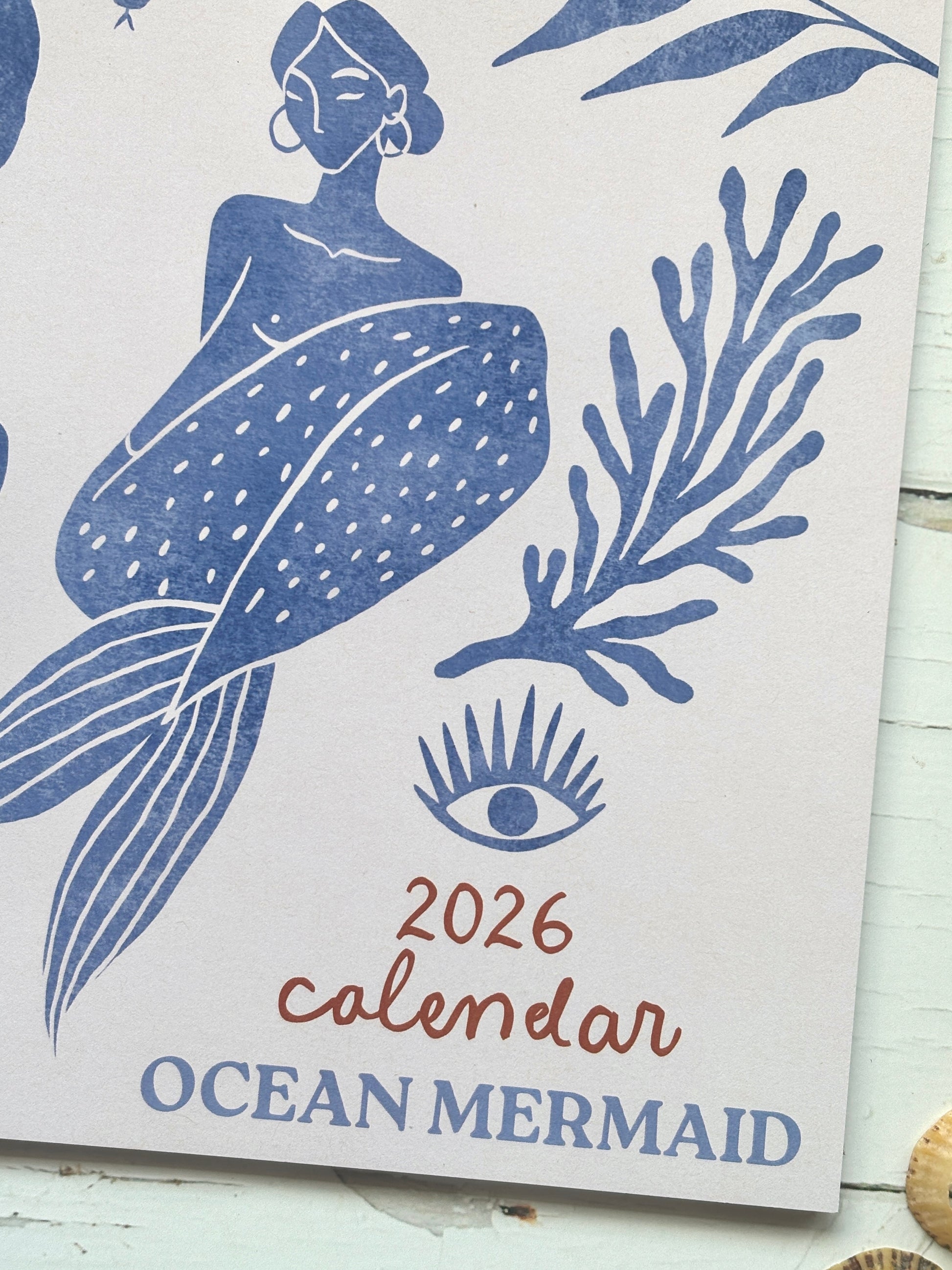 ocean mermaid 2026 calendar—blue mermaid art with seaweed and eye motif, perfect for coastal décor, planning, and gifting