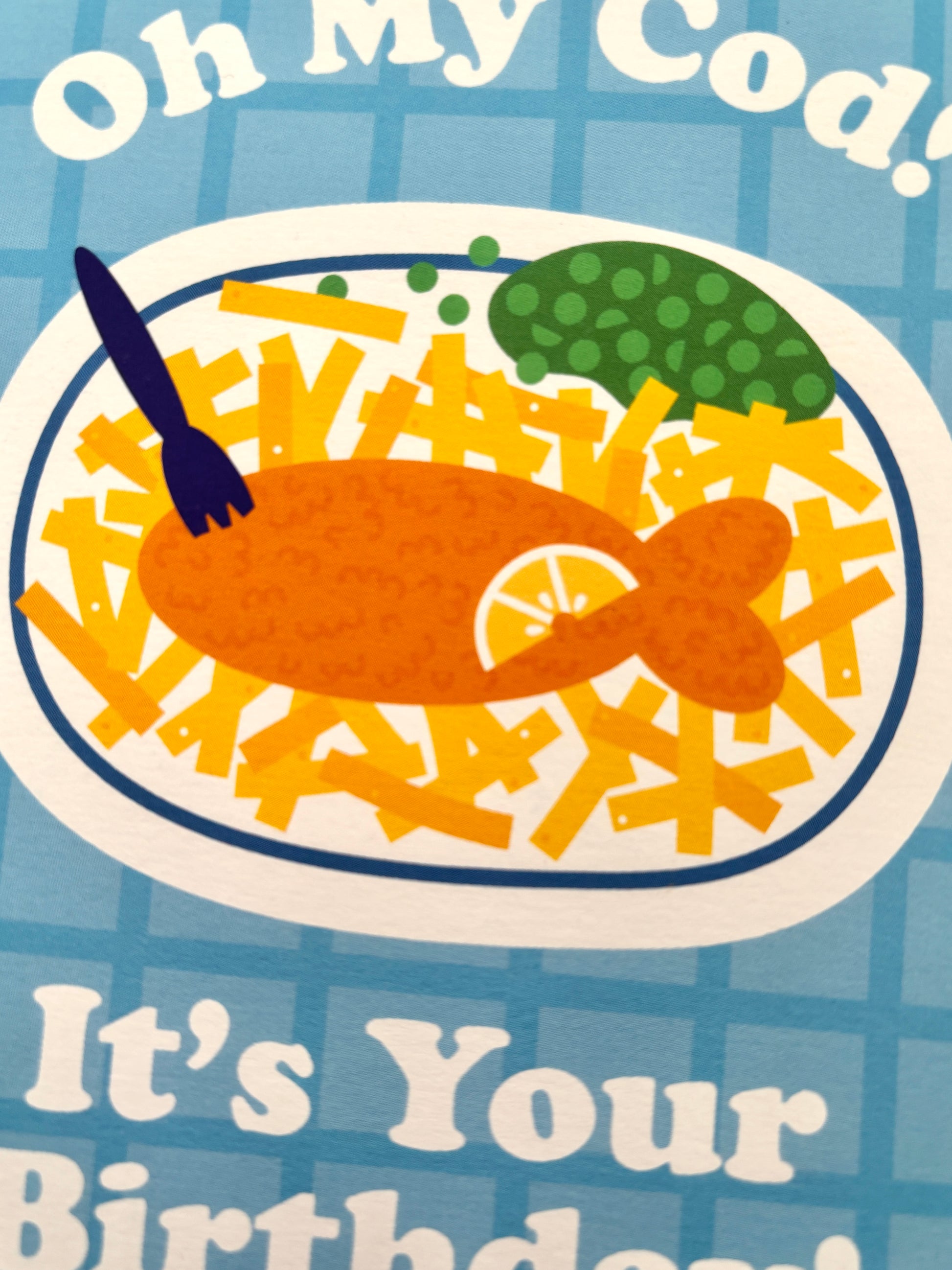 closeup shot of playful UK fish and chips birthday card with punny “Oh My Cod” text and cartoon-style food illustrations