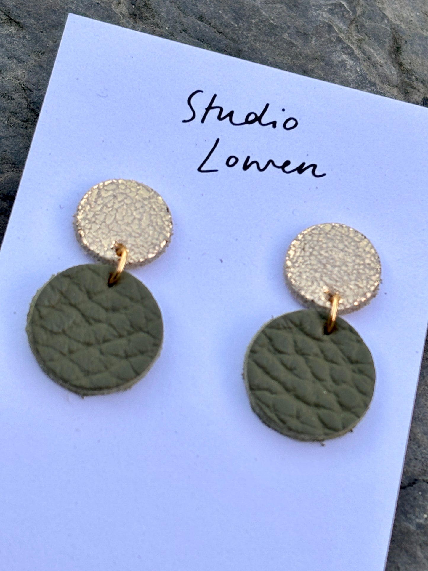 closeup shot of olive green leather drop earrings—handmade, gold-detailed, perfect for holiday outfits and modern minimalist style