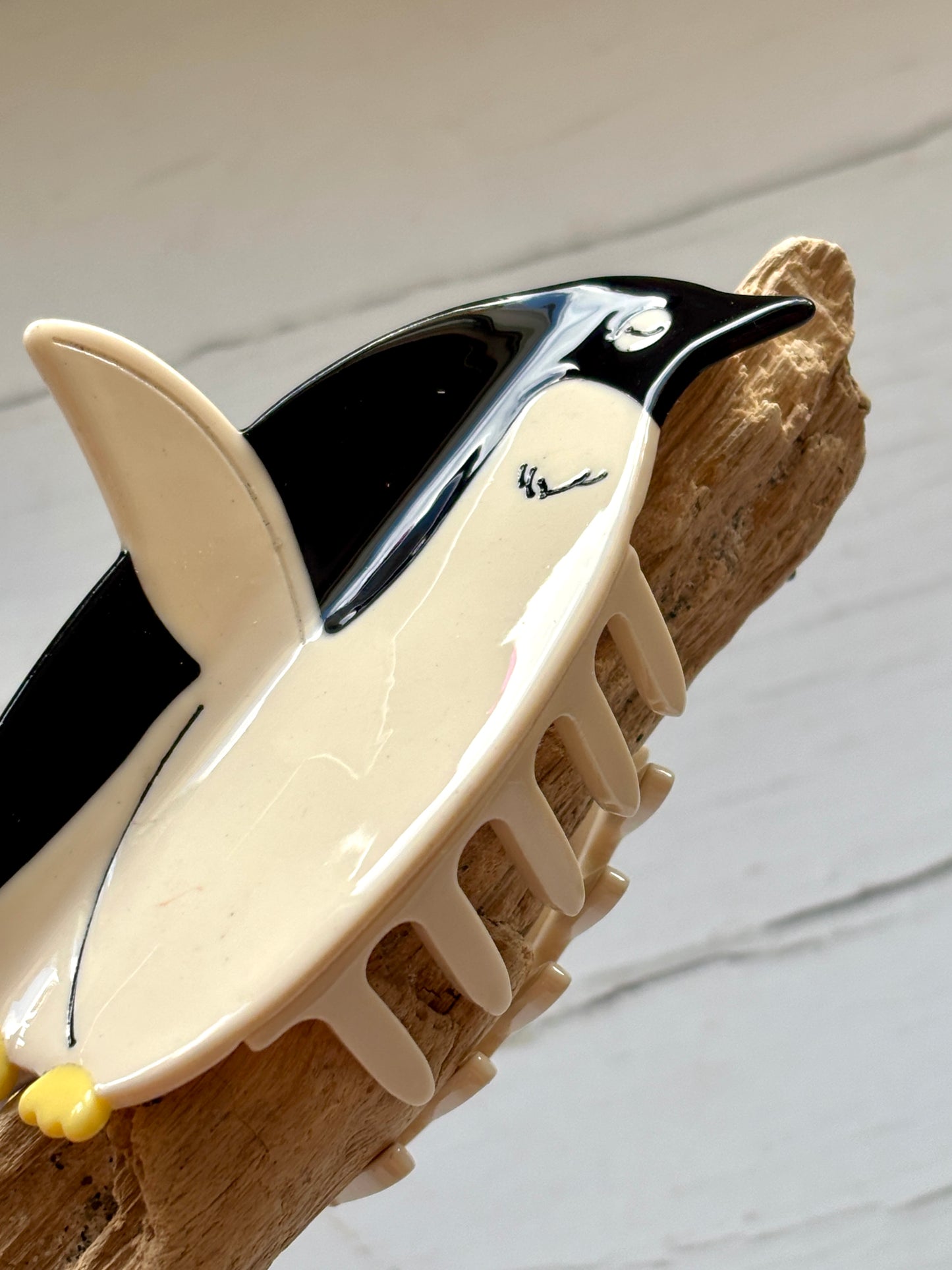 closeup shot of penguin hair claw clip—glossy finish, secure grip, and playful charm for animal-inspired styling