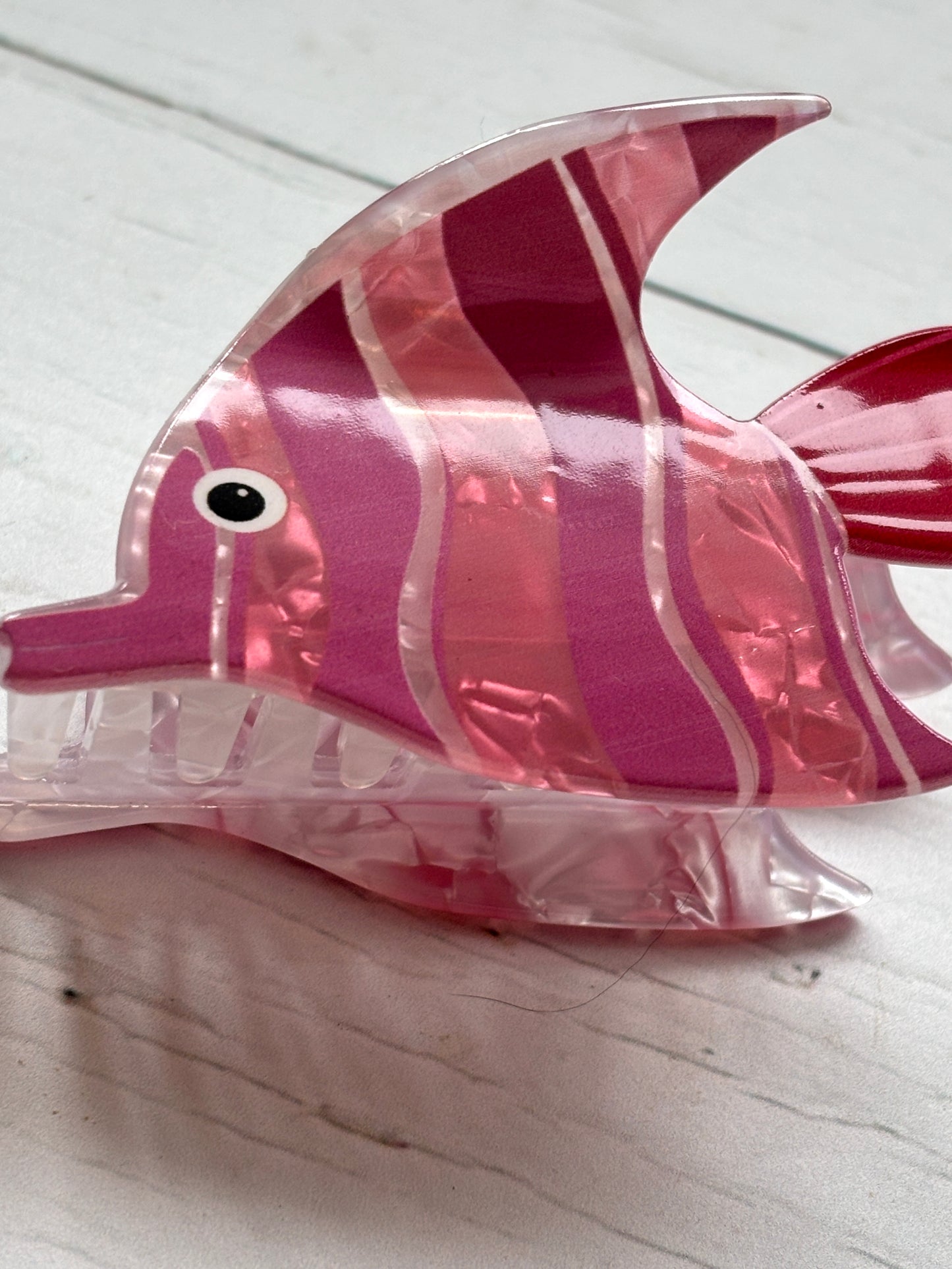 closeup shot of the striped pink angelfish hair claw clip, showing the marble texture, eye detail, and clear gripping teeth ocean accessory