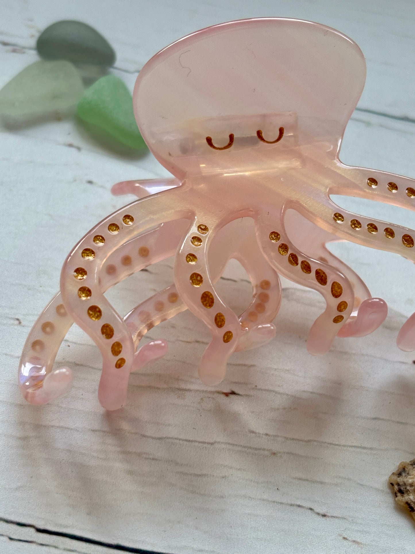 closeup shot of pink octopus hair claw clip with gold glitter spots cute sea creature, resin, nautical, beach-themed hair accessory