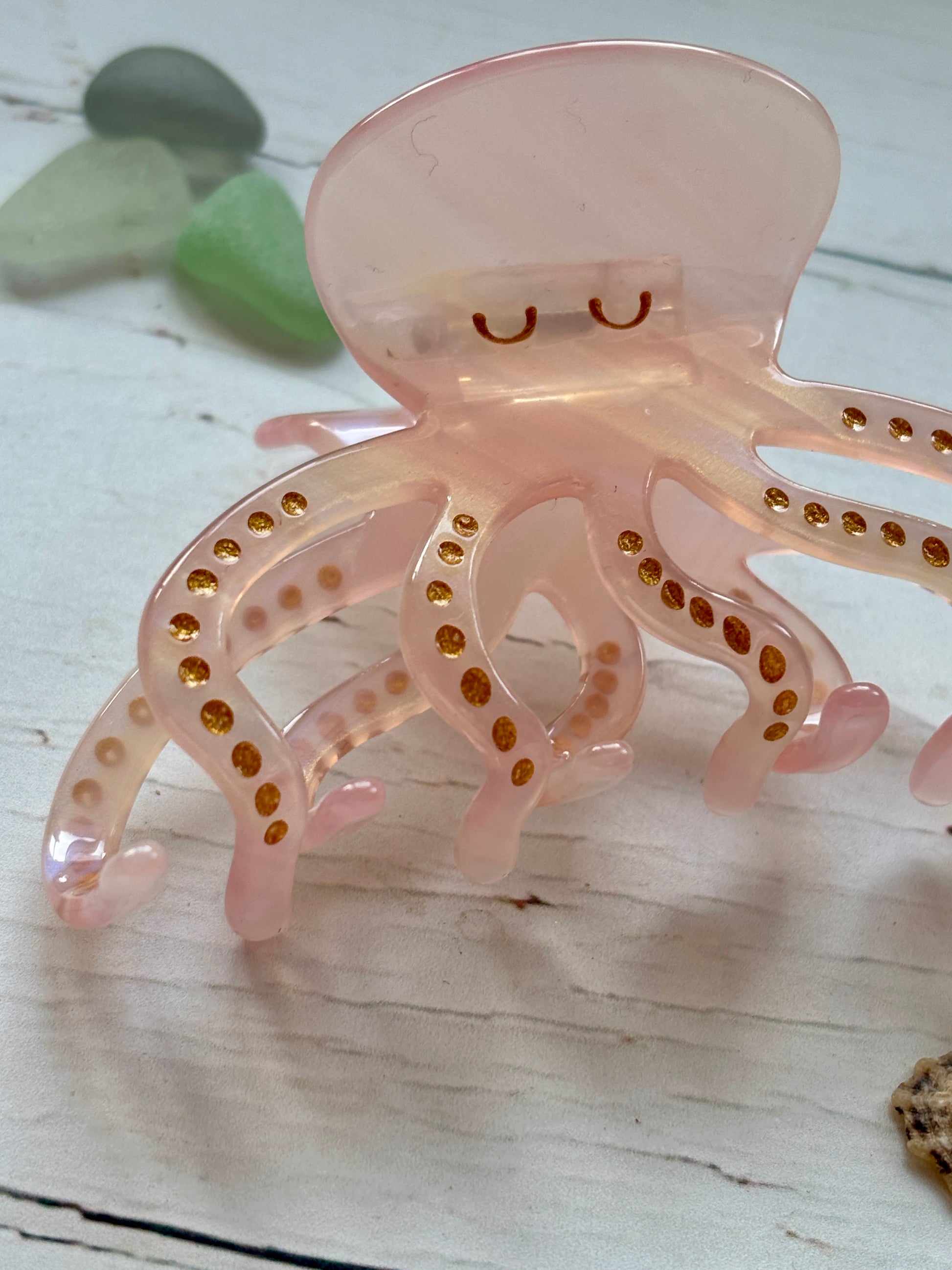 closeup shot of pink octopus hair claw clip with gold glitter spots cute sea creature, resin, nautical, beach-themed hair accessory