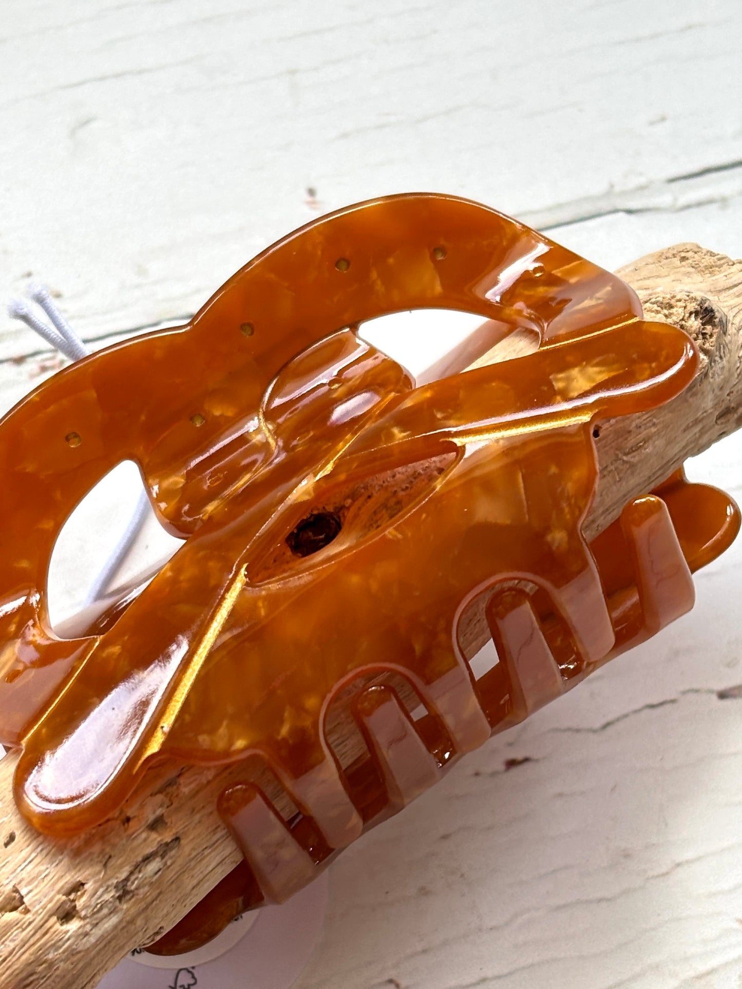 closeup shot of pretzel hair claw—tortoiseshell marbled clip with glossy finish, strong grip, and snack-inspired style