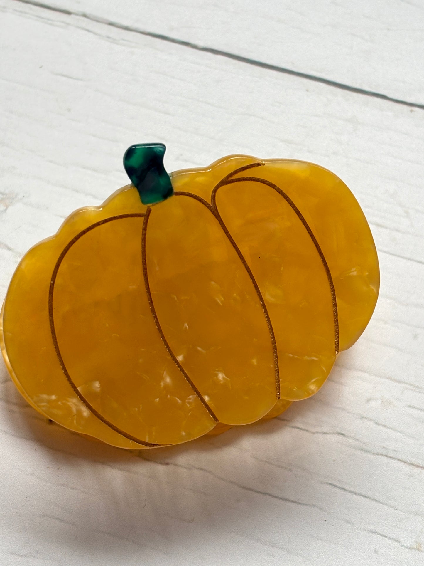 pumpkin hair claw in glossy marbled yellow with green stem—festive fall clip for secure, playful styling