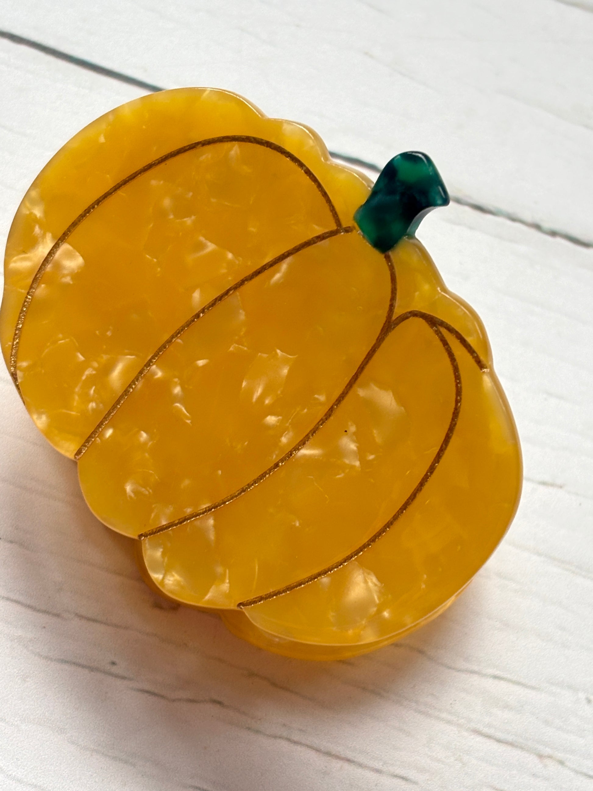 glossy marbled pumpkin hair claw with striped segments and green stem—playful fall accessory with strong grip