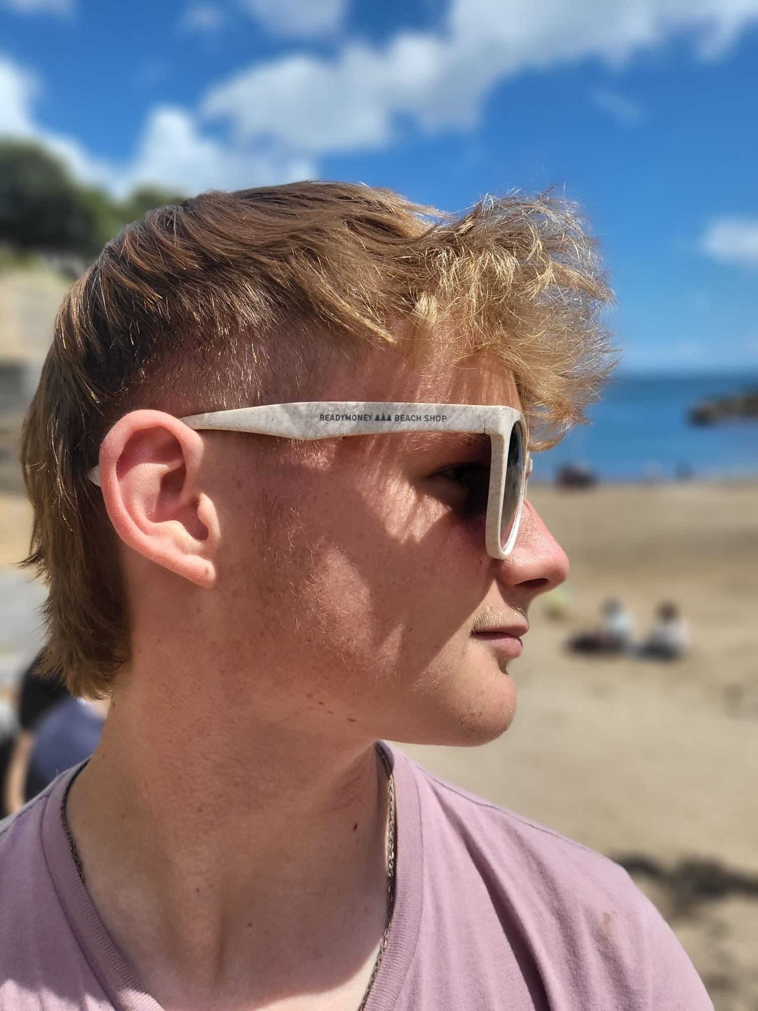 lifestyle photo of 'Readymoney Beach Shop' eco-friendly sunglasses worn by model sustainable beach eyewear, recycled plastic frame