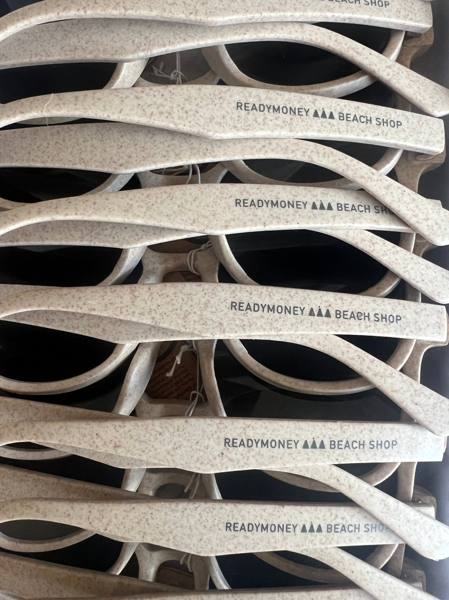 stacked eco sunglasses with speckled frames and bold branding—stylish, sustainable, and beach-shop ready