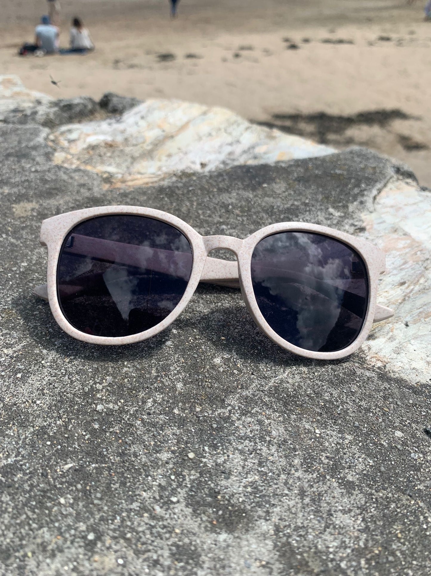 eco-friendly sunglasses for 'Readymoney Beach Shop.' beige/pink recycled plastic frame, black lenses, beach eyewear, sustainable style