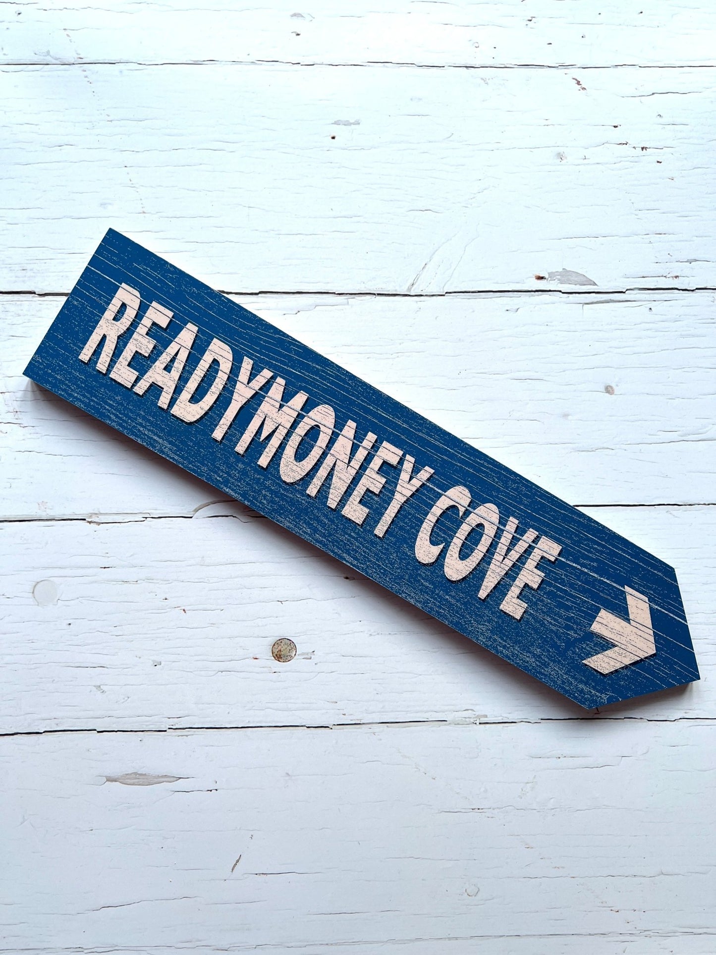 blue 'Readymoney Cove' single direction arrow sign coastal beach decor, vintage effect, wooden wall art, nautical theme