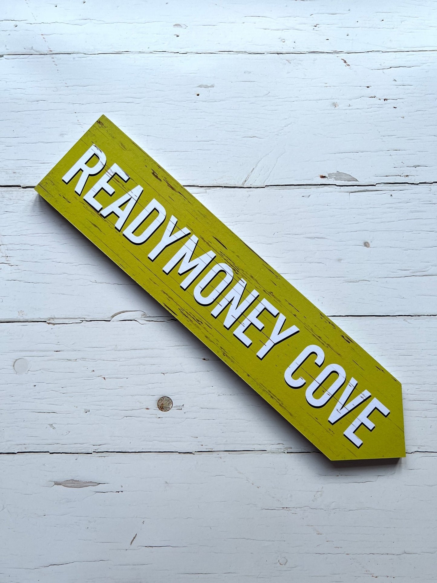 yellow 'Readymoney Cove' single direction arrow sign coastal beach decor, vintage effect, wooden wall art, nautical theme