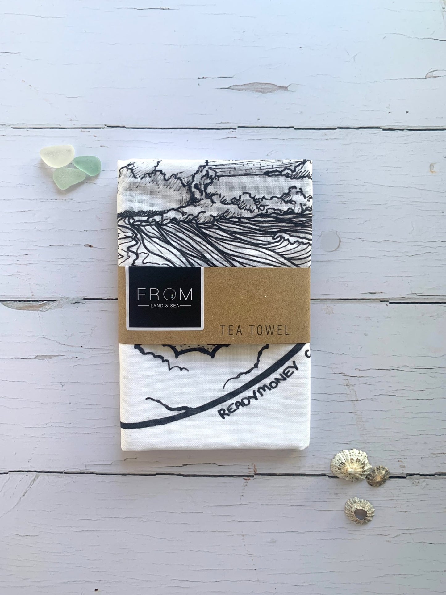 Readymoney Cove tea towel—black and white coastal illustration with beach and trees, ideal for nautical kitchen styling