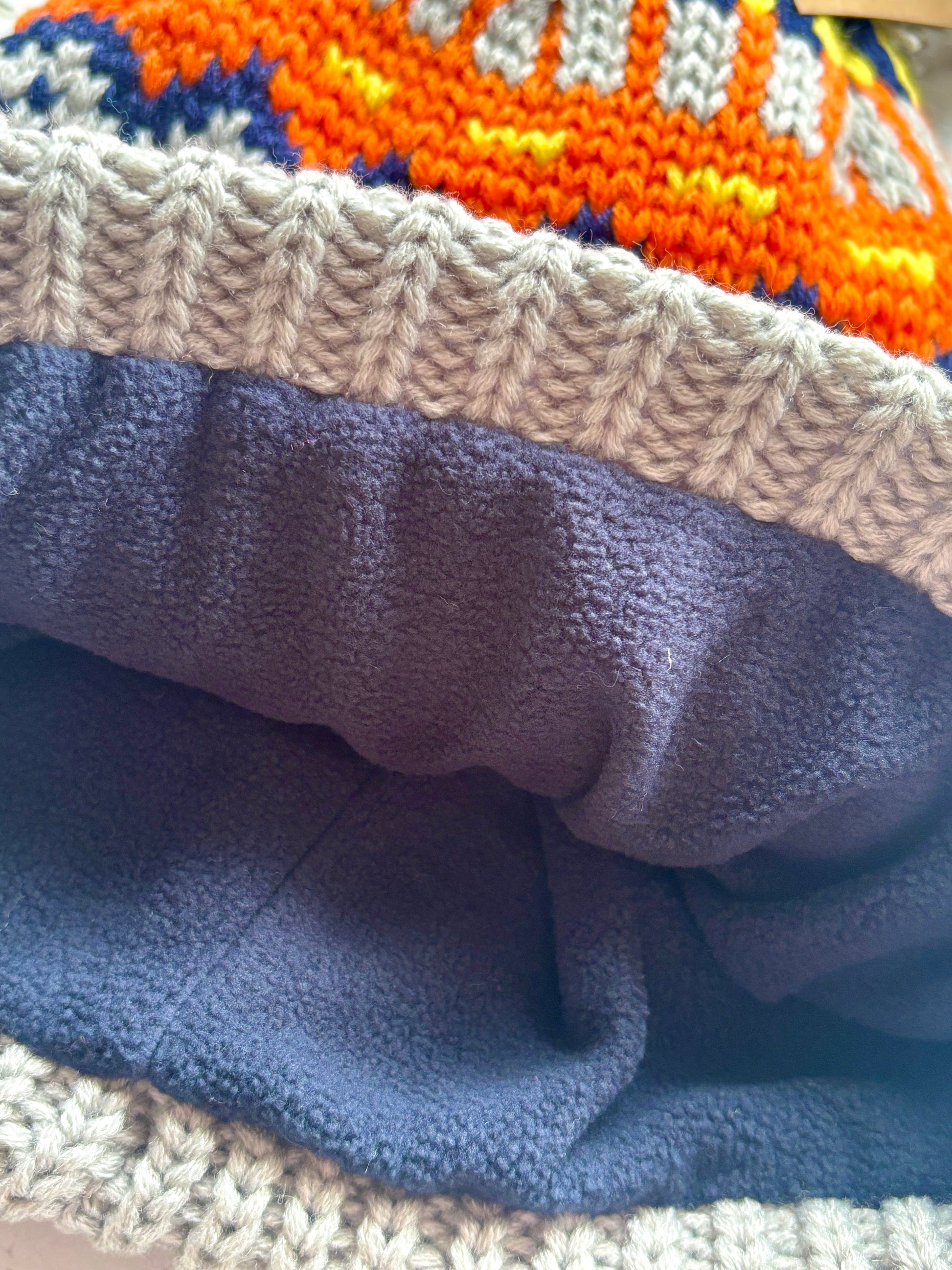 retro knit bobble hat with fleece lining, gray ribbed brim, and vibrant zigzag pattern—warm, stylish winter essential